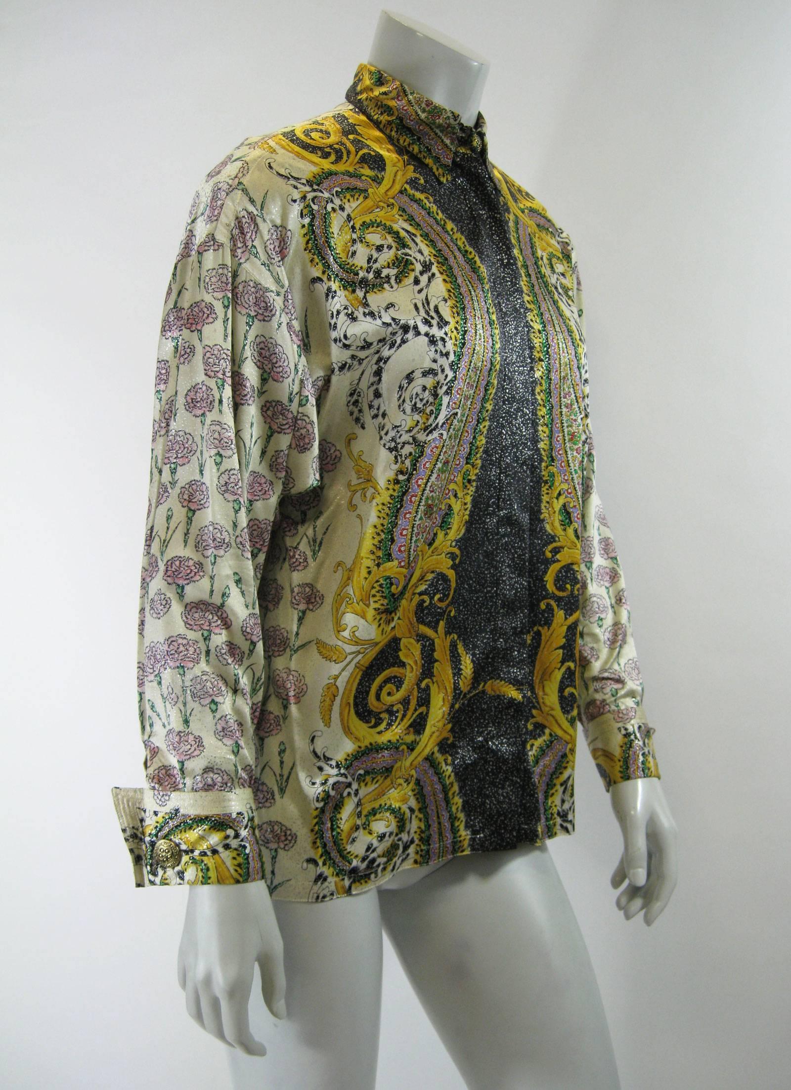 Vintage Gianni Versace silk blouse.
Cream with pale pink flowers, silver metallic speckles
with gold, green, black, red and lavender swirling patterns.
Hidden button placket.
Button down collar,
French cuffs with detailed buttons.
No size