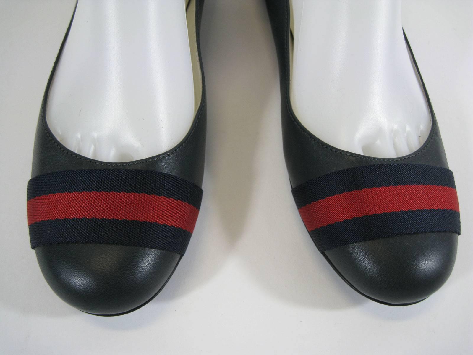 Navy blue leather Gucci flats.
Navy and red ribbon trim on round toes.
Flexible soles.
Marked a size 36 1/2.
