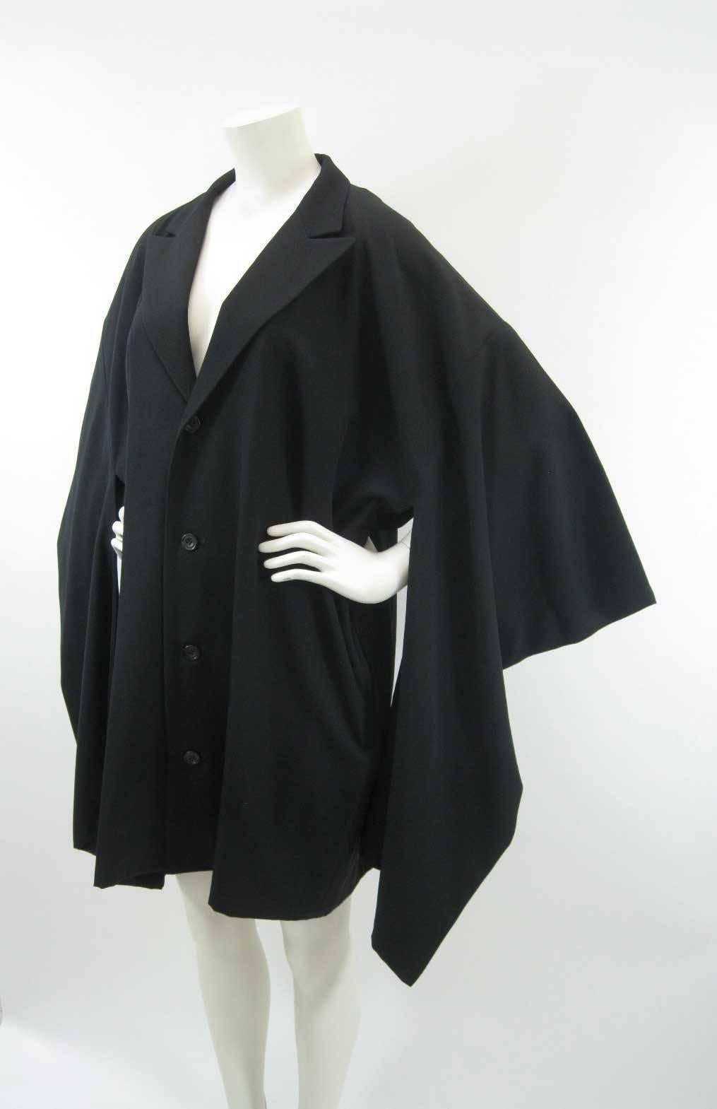 Black Yohji Yamamoto Japanese traditional with a twist style coat.

Boxy shape with long columns that hang from sleeve.

Fold over collar.

Four button closure.

Unlined.

Tagged size M. (This item is listed as unisex however it is sized a men's