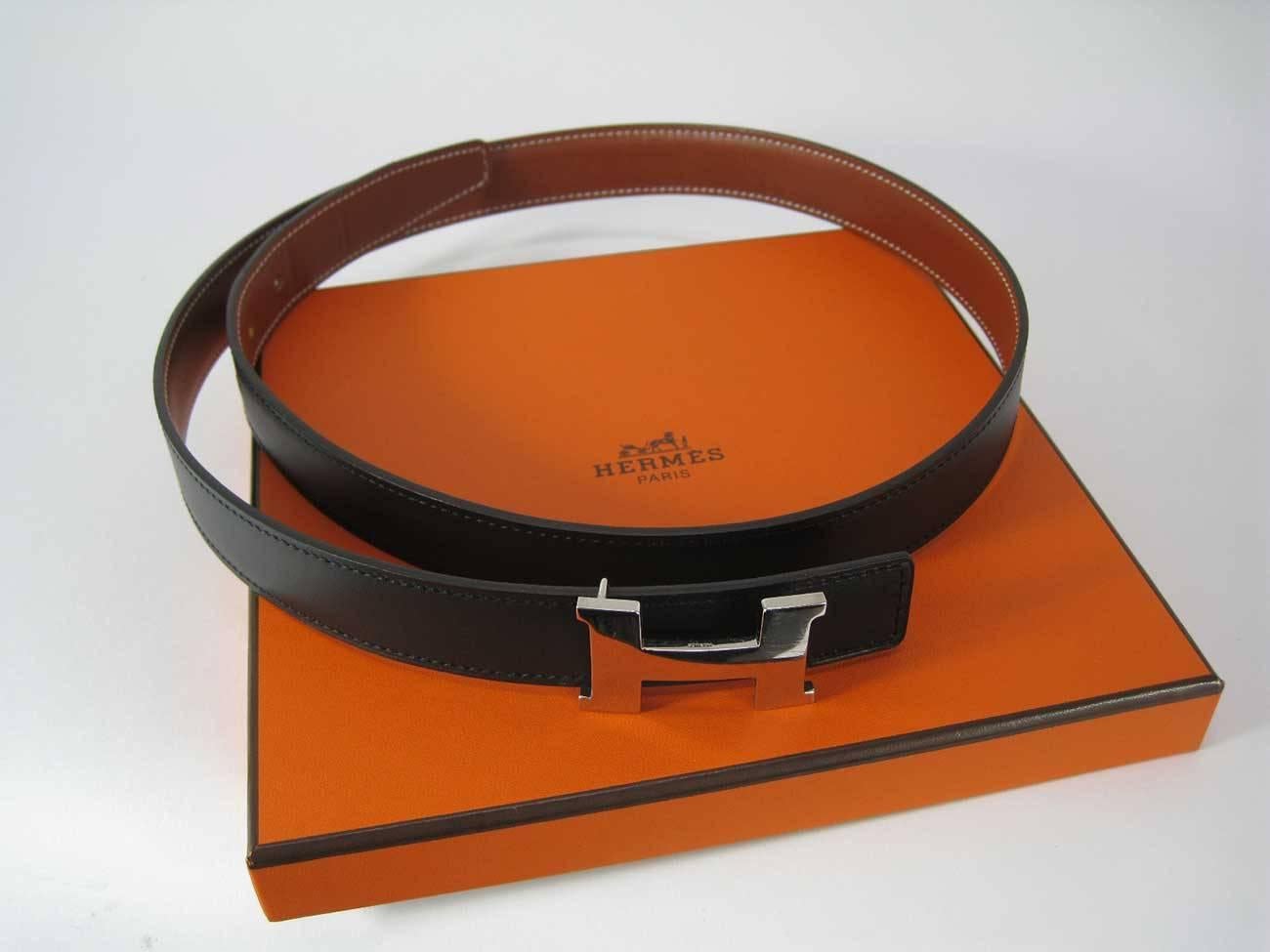 Fabulous Hermes H Belt Buckle with reversible strap.

Black and light brown leather strap with three holes for size adjustment.

Belt and buckle come with original box and packaging.

Buckle is shiny silver metal with matte back.

This item is in