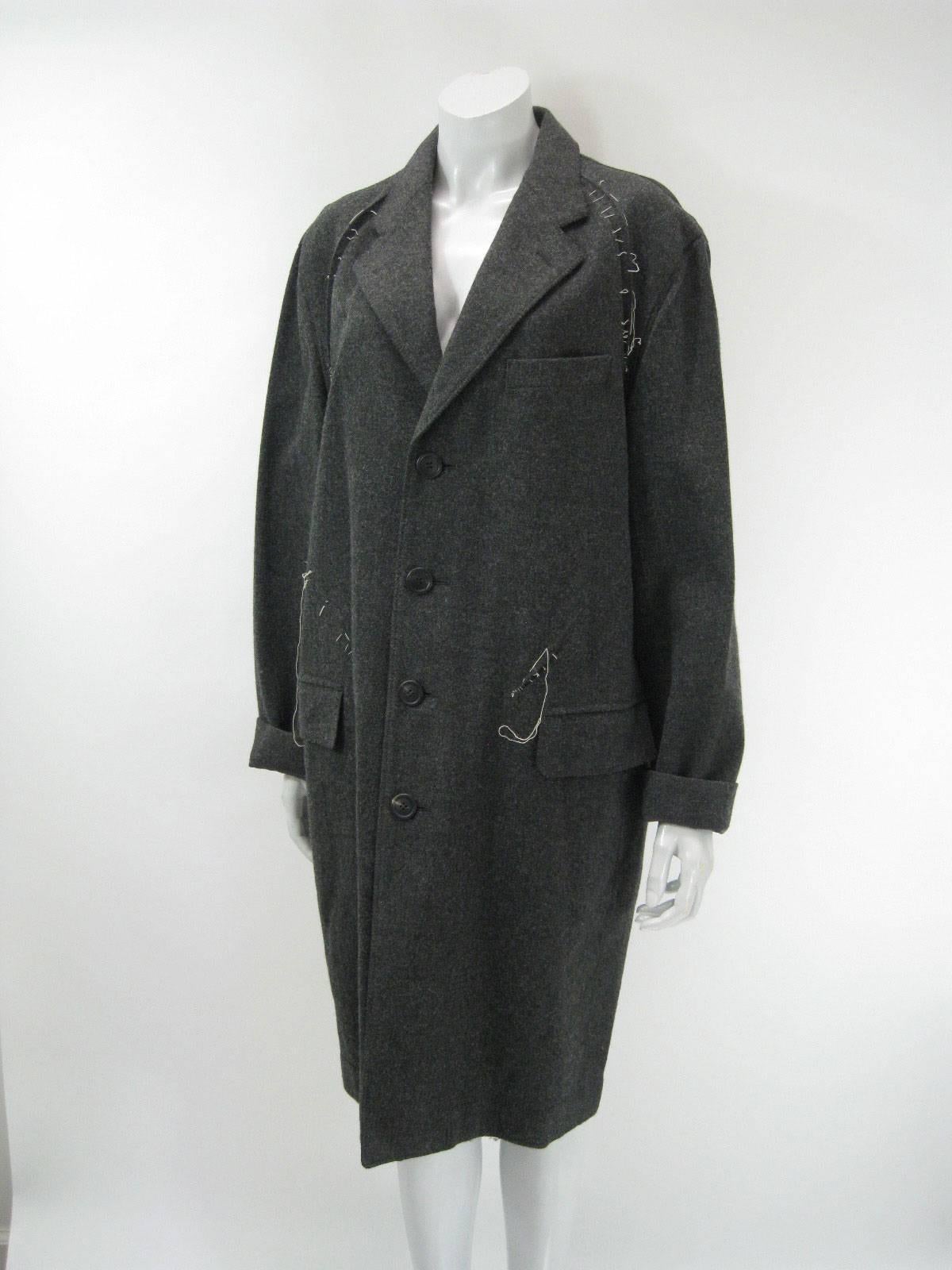 Avant Garde Issey Miyake Men wool coat.

Grey with white threaded abstract stitched details.

Front patch pockets. One chest pocket.

Inverted pleat back with pleats and stitches.

Large charcoal grey buttons.

Unlined.

Tagged size 3.

Fabric is
