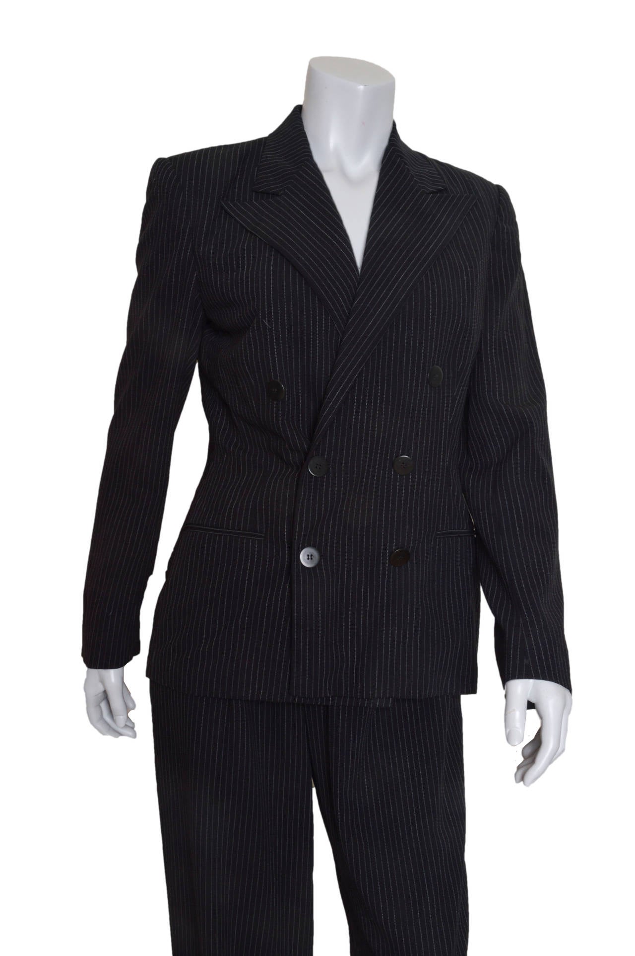 Ralph Lauren Collection double breasted pant suit.
Purple Label.
A feminine take on a very masculine shape.
Black with white pinstripes.
Slightly fitted jacket with padded shoulders for shape.
Front slit pockets.
Button detail on wrists.
Wide legged