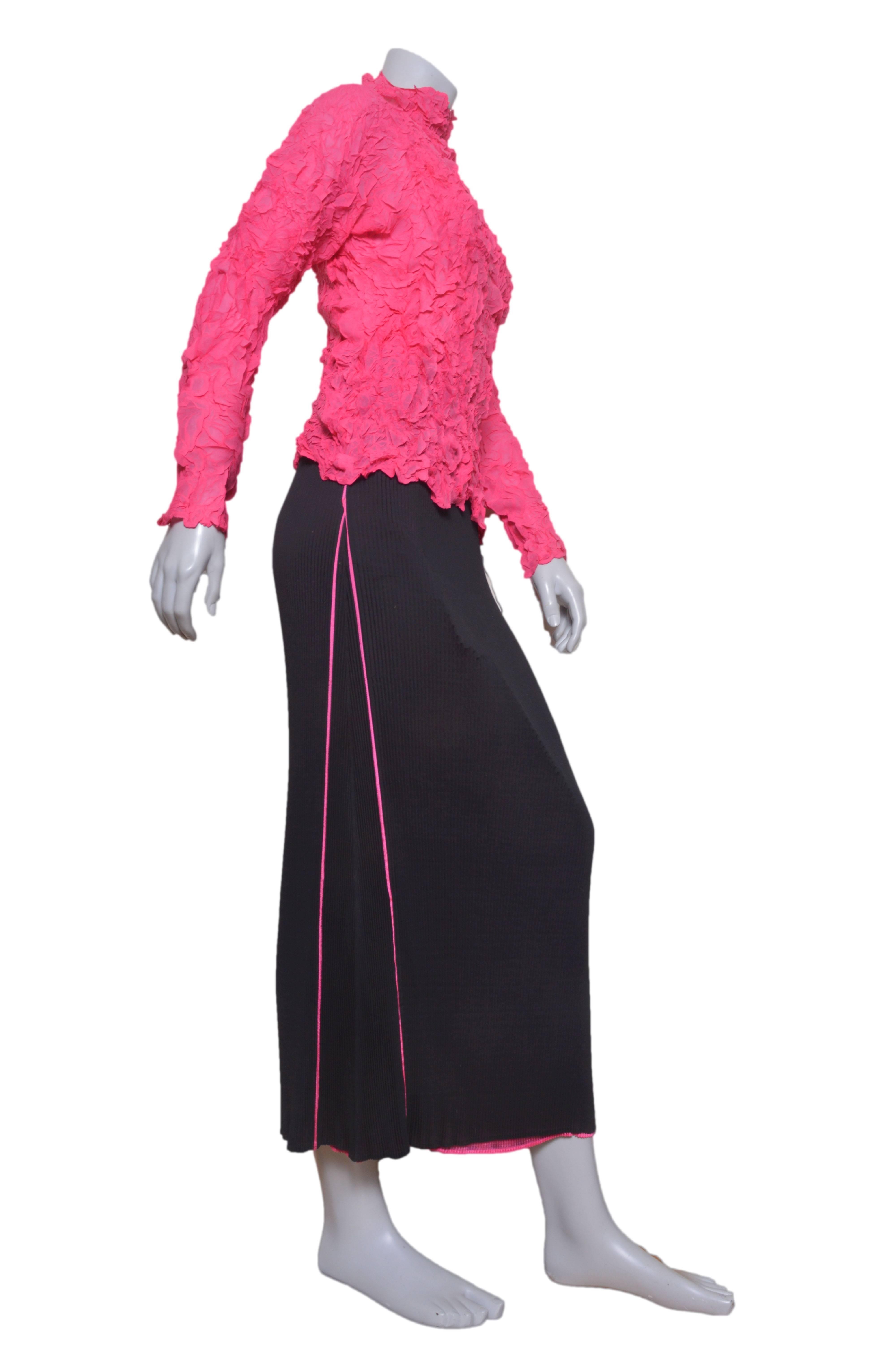 Stunning Issey Miyake blouse and skirt set.
Lightweight crinkled hot pink top with high neck and neck long sleeves.
Pleated long black straight skirt with pink pipping and underskirt.
Elastic waist.
Tagged a size Medium.

Top