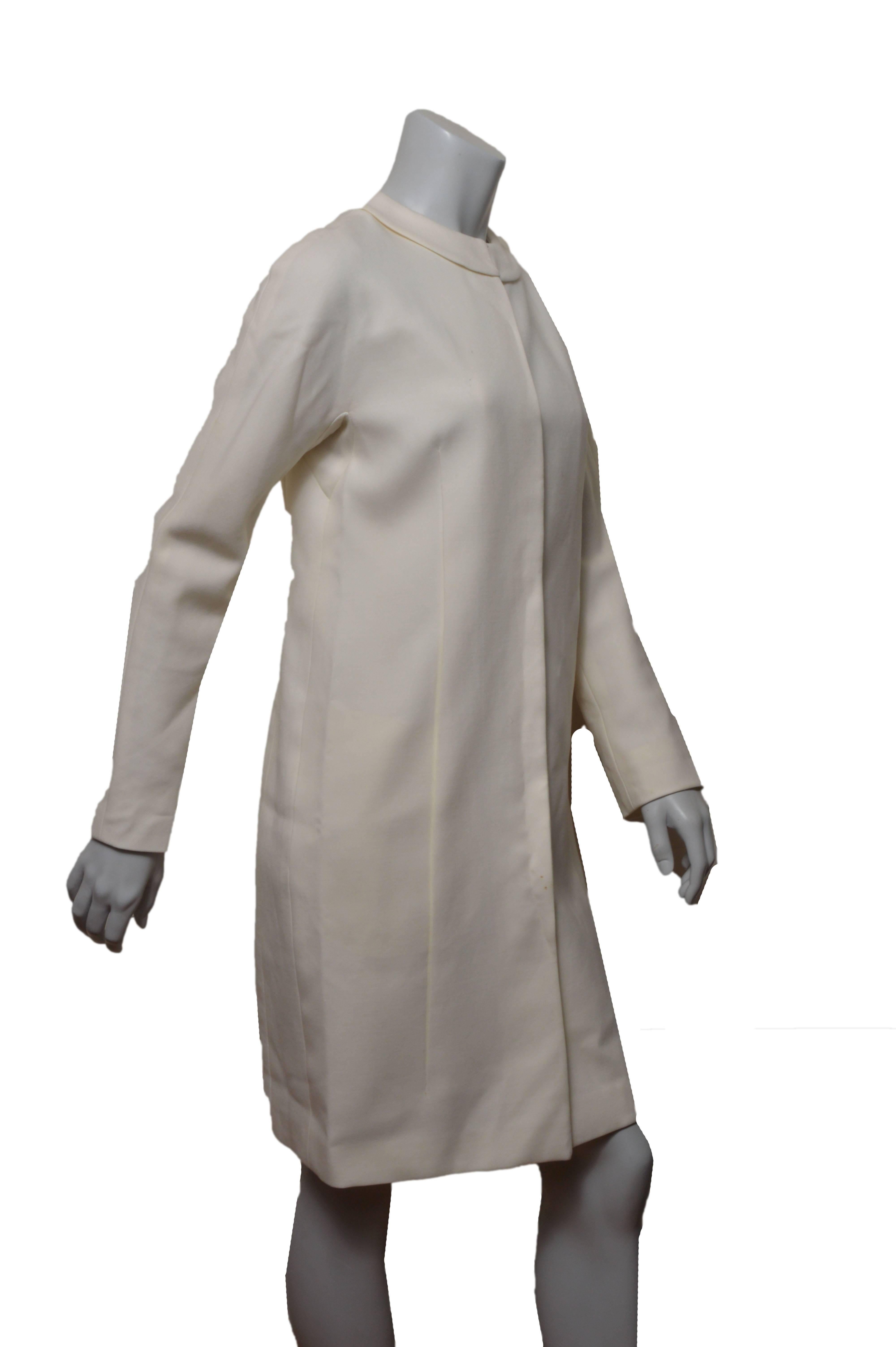 Minimalistic Jil Sander cream coat.
Round peter pan collar with hook and eye closure.
Two inverted pleats on front.
Hidden 5 button closure.
Lined.
Tagged a size 34.