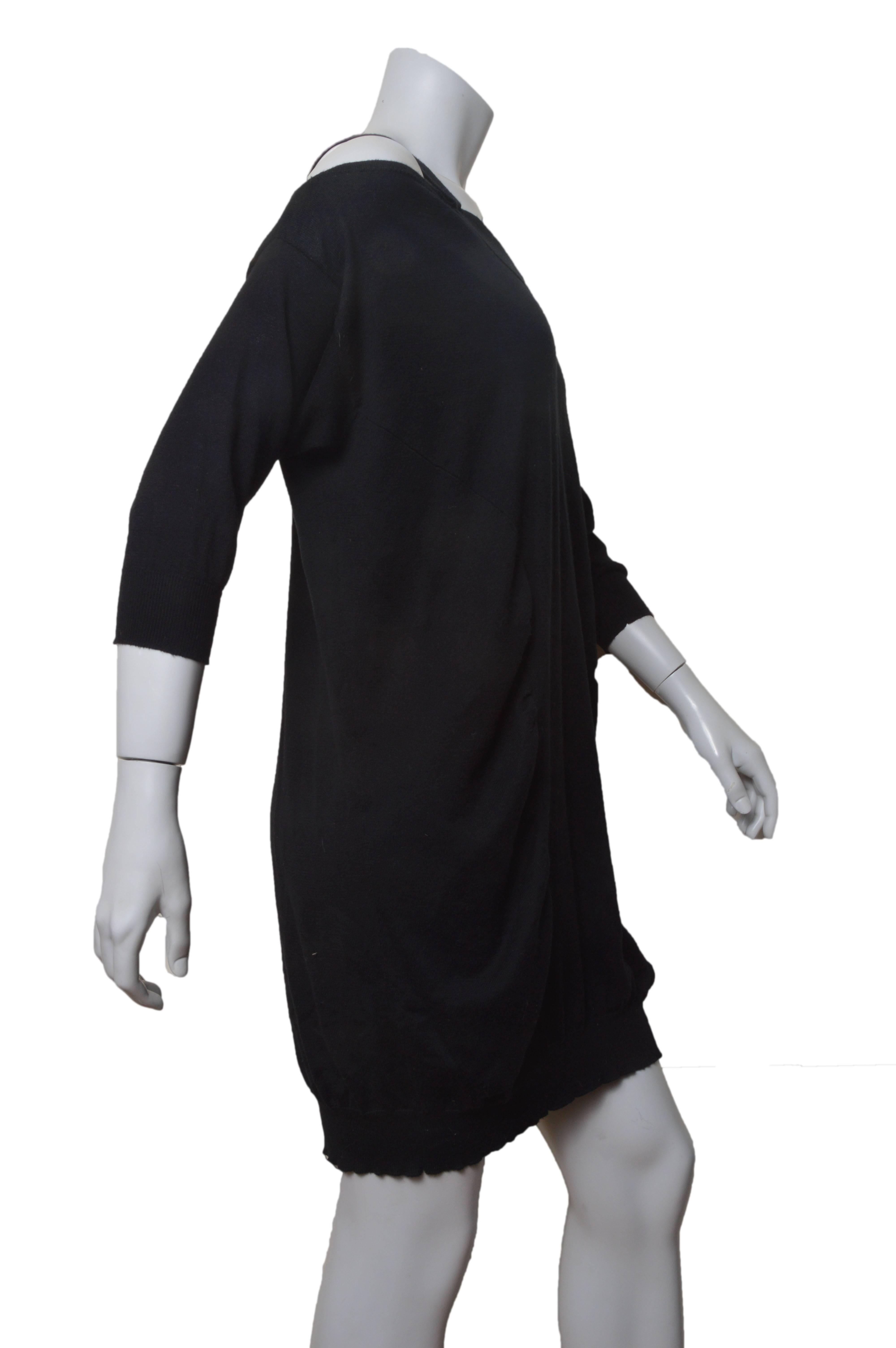 Black Miu Miu lightweight sweater dress.
Loose, slouchy fit.
Cut out shoulder detail.
Slight ruching on side panels.
Elbow length sleeves.
Banded bottom hem.
No size tag found.