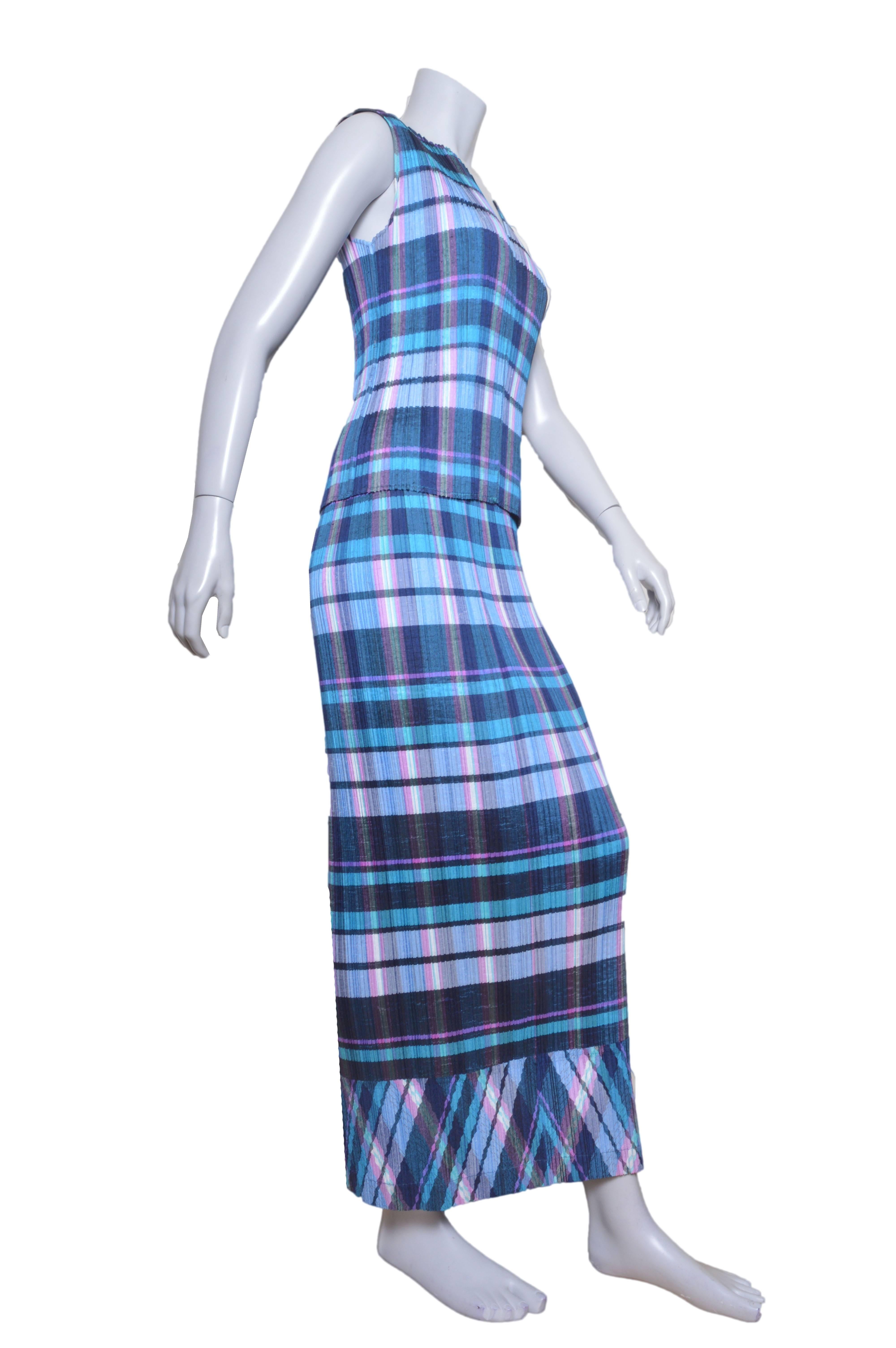 Timeless Issey Miyake plaid skirt and blouse set.
All over vertical pleating.
Deep blue, teal, purples and a bit of turquoise.
Blouse is sleeveless with V notch collar.
Long straight skirt with contrasting diagonal plaid hem detail.
Elastic