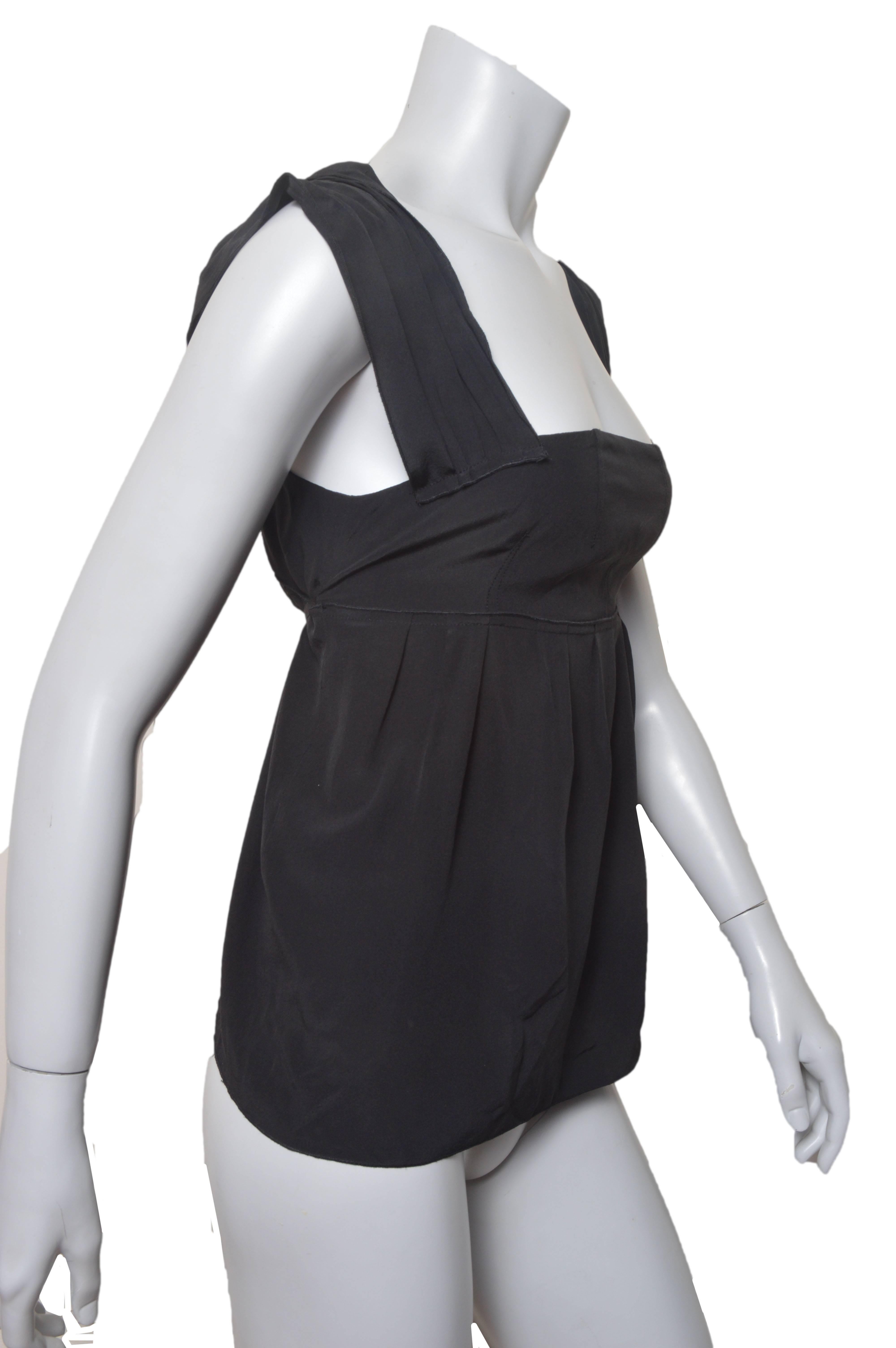 Lovely Miu Miu black sleeveless blouse.
Pleated shoulder straps.
Fitted top with empire waist.
Loose inverted pleat hem. 
Self tie at waist.
Side zipper.
Tagged a size 42.