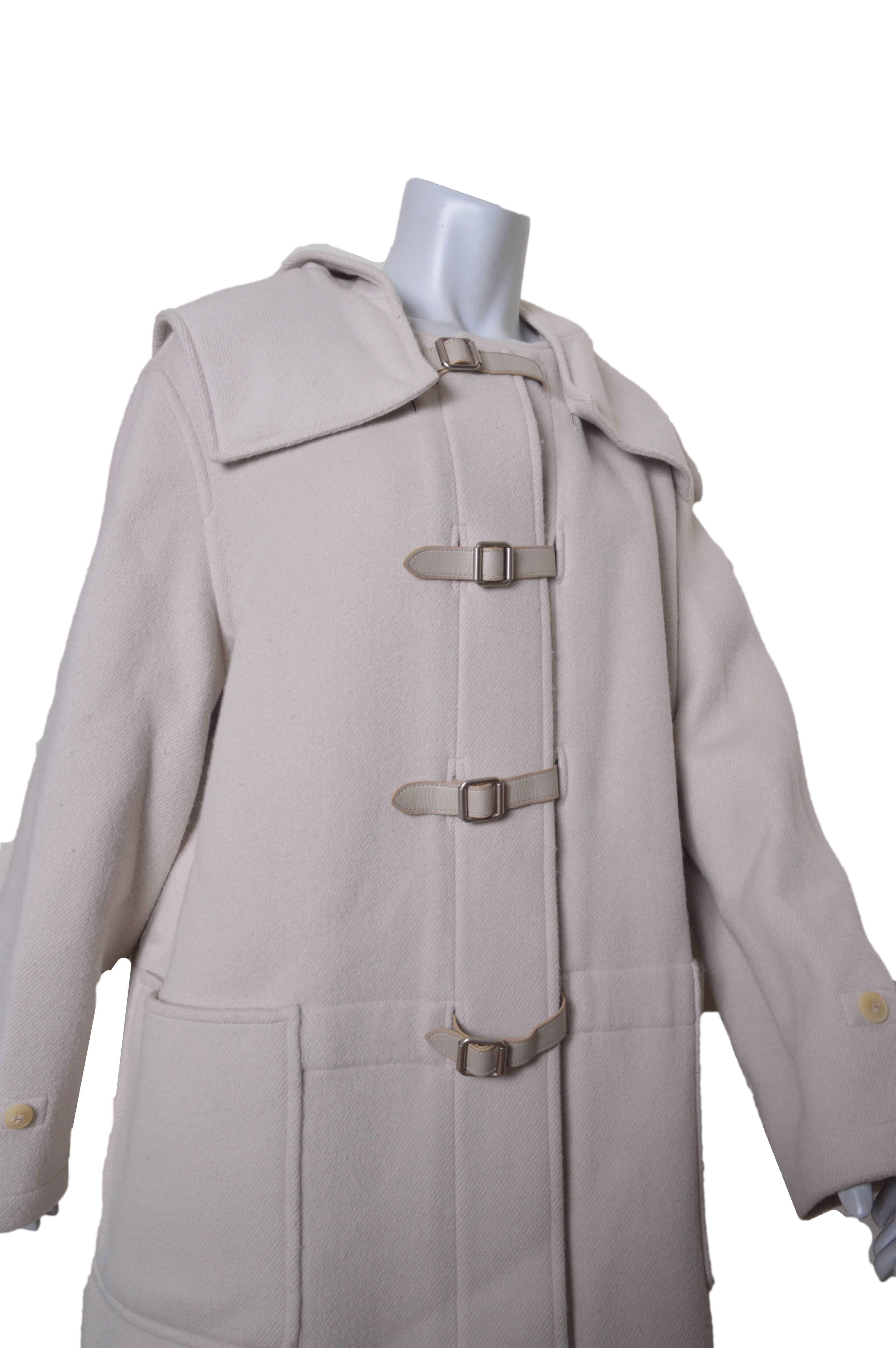 Lush Hermes coat.
Color is a very pale gray/cream.
Wool with cashmere.
Detachable hood.
Leather belt and buckle closures.
Huge front bucket pockets.
Shoulder amulets.
Unlined.
Tagged a size 44.