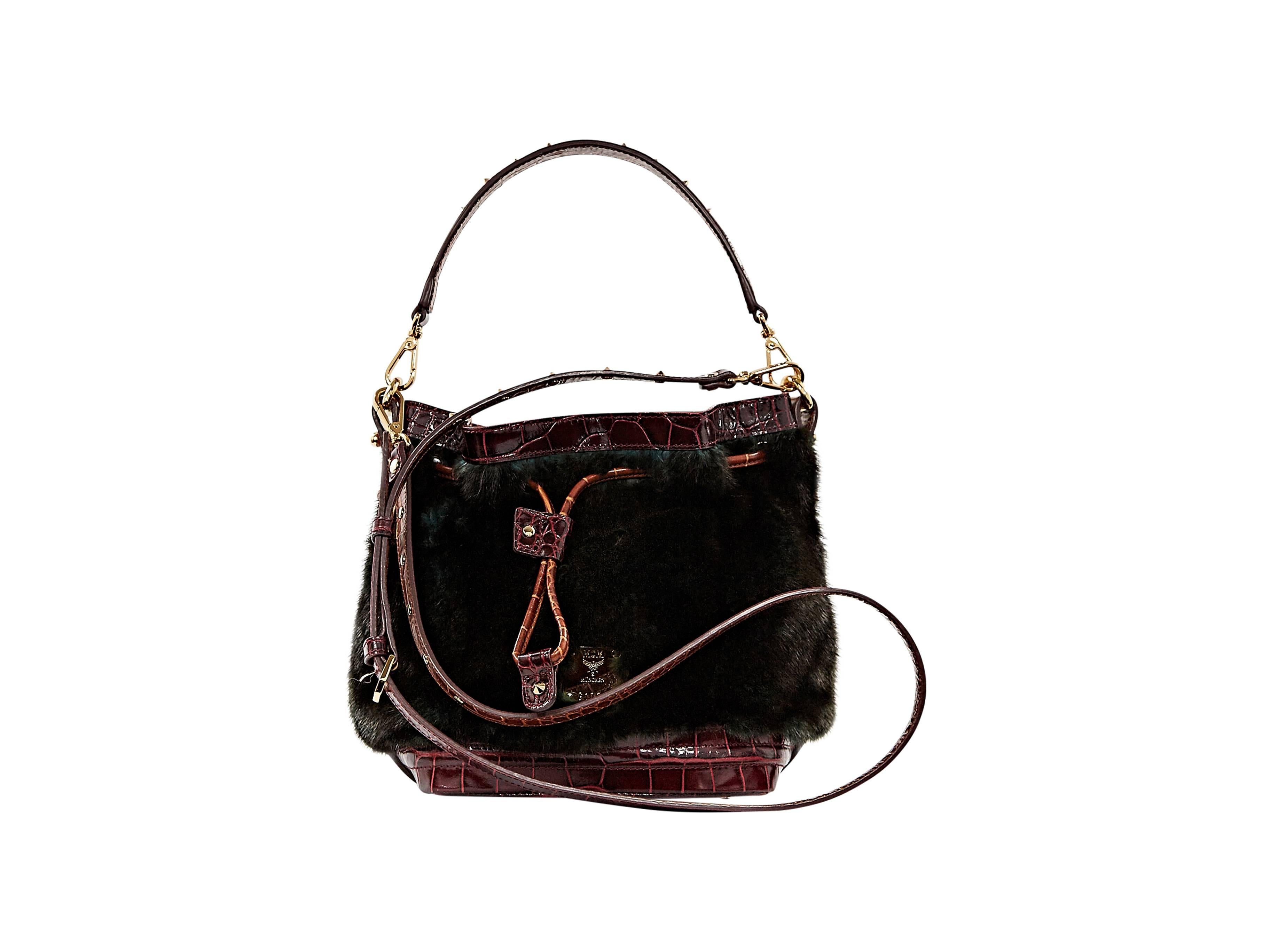 Dark green fur satchel with burgundy snake-embossed leather trim by MCM.  Removable studded top handle and shoulder strap. Drawstring accent.  Protective metal feet.  Goldtone hardware.
