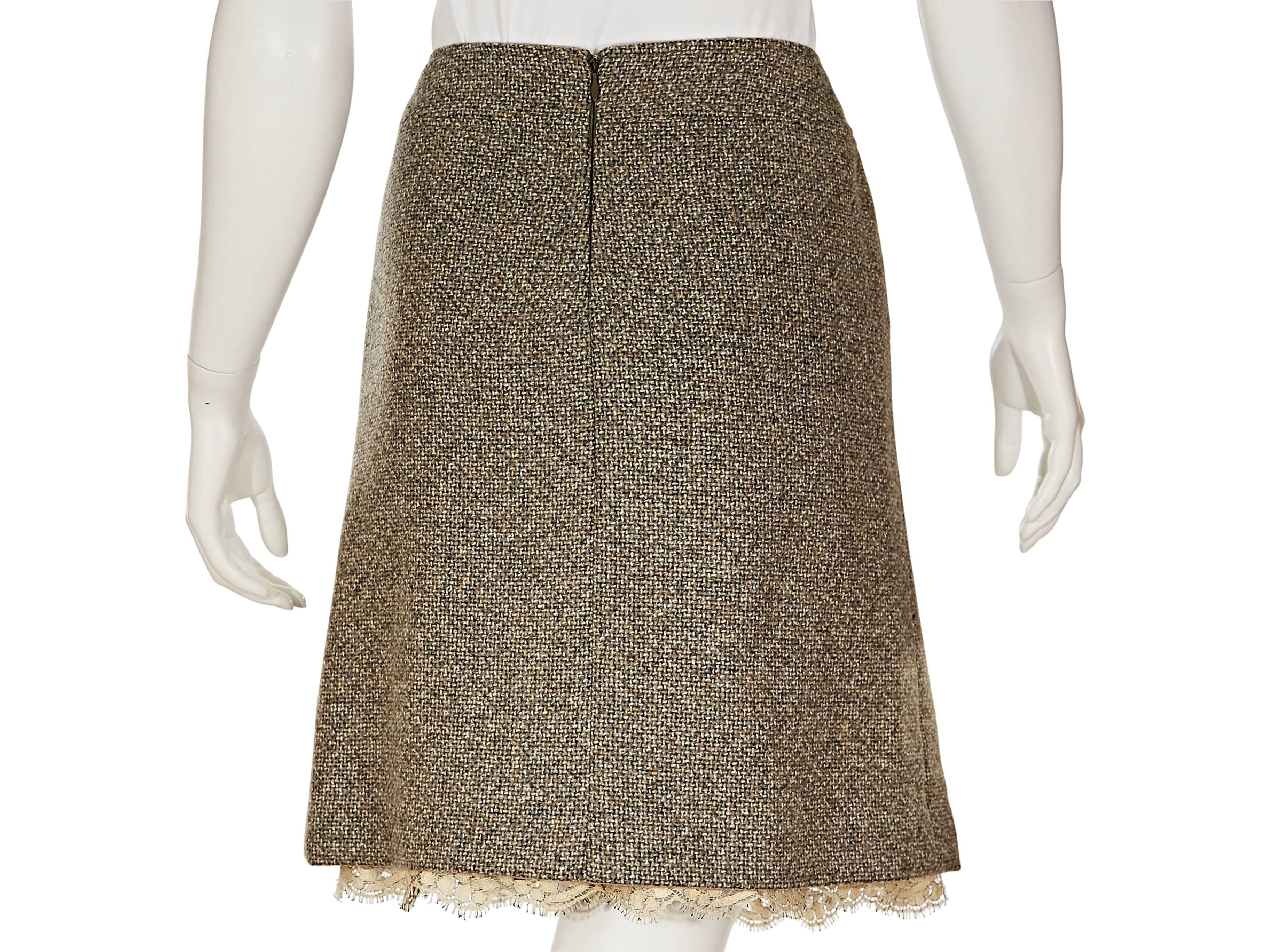 Grey tweed A-line skirt by Chanel.  Banded waist with goldtone logo charm.  Concealed back zip closure.  Lace hemline. 

European sizing is converted to US size at New York based store.