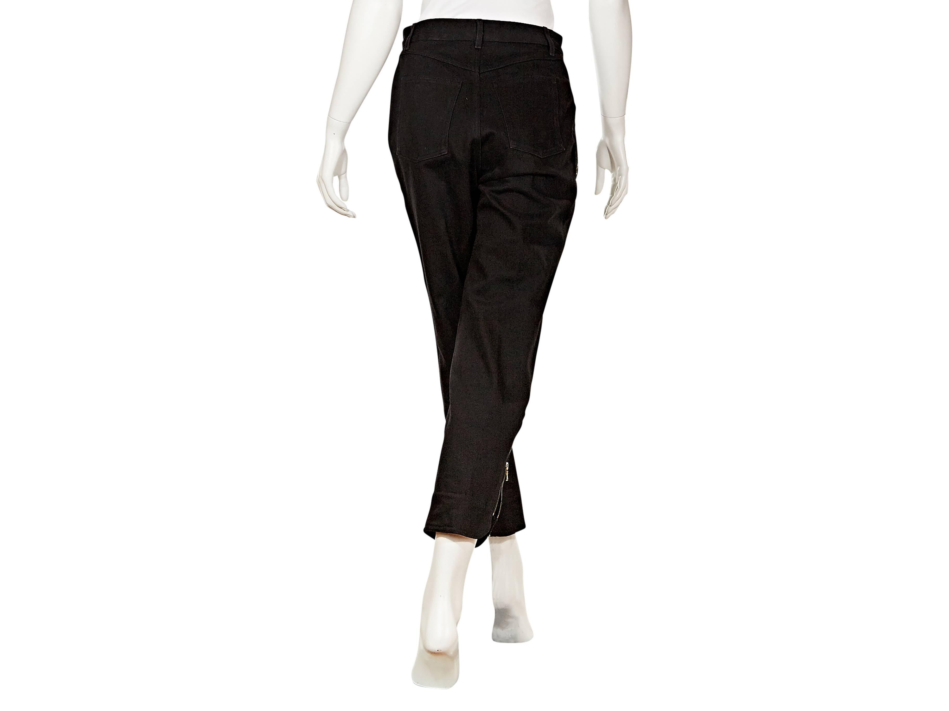 Black cropped cotton jeans pants by Chanel.   Zip pockets add edgy moto style. Looped waist.  Button closure with zip fly.  Back patch pockets.  Outer zip ankle cuffs.  Goldtone hardware.

French sizing converted to US sizing at NYC store.