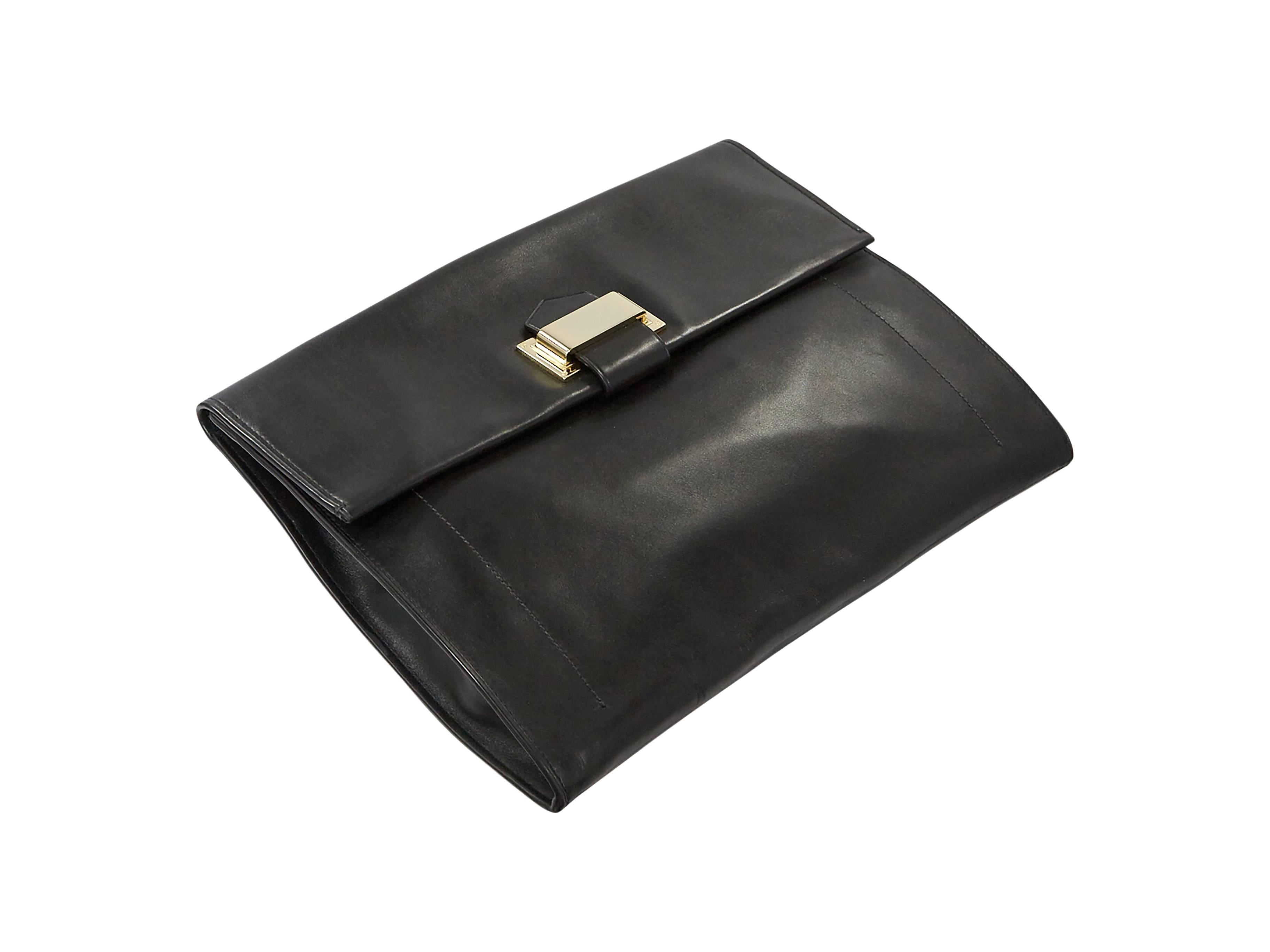 Black leather oversized clutch by Reed Krakoff.  Front flap accented with tab accent.  Magnetic snap closure.  Goldtone hardware.  13