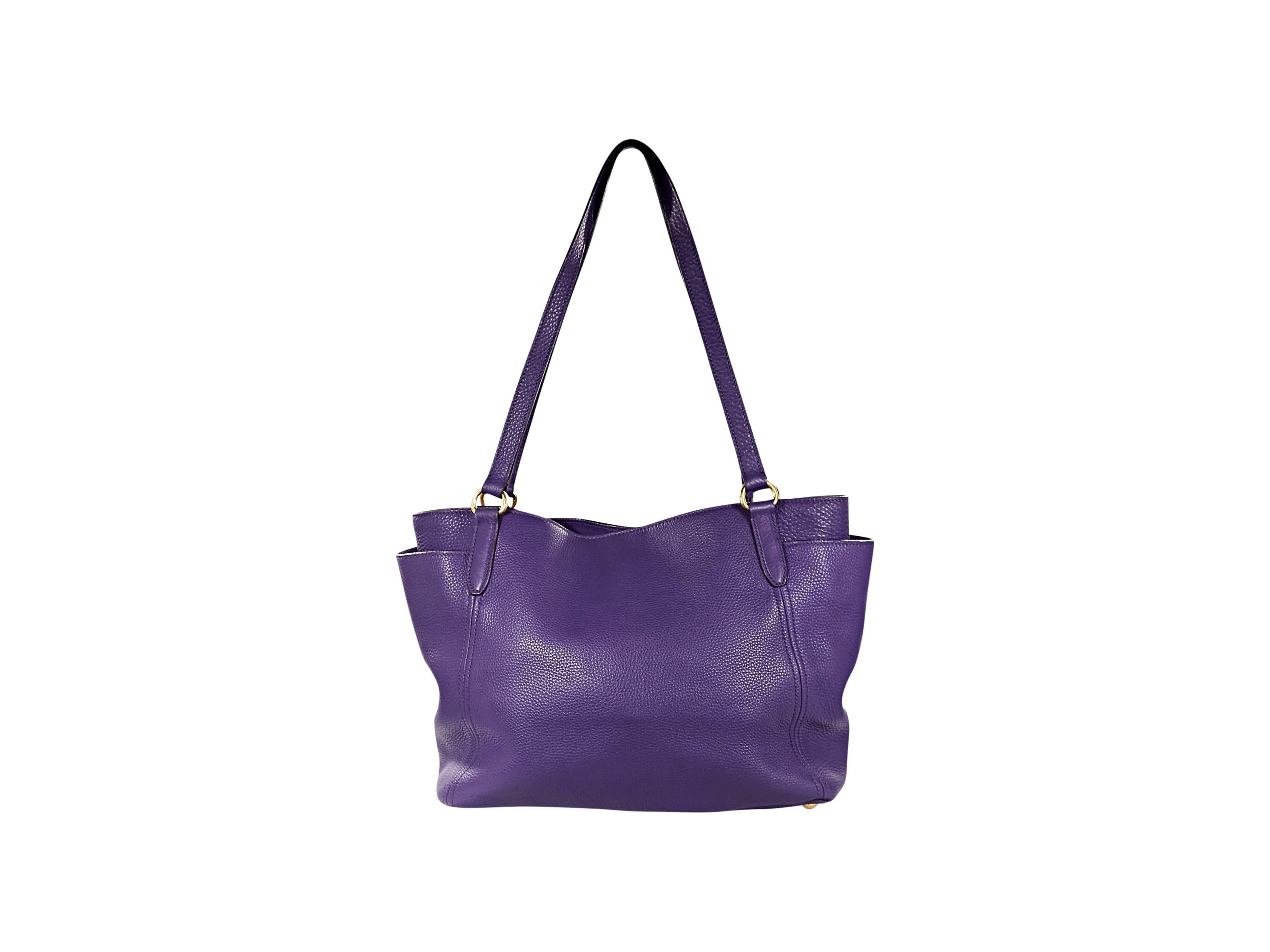 Purple pebbled leather tote bag by Prada.  Double shoulder straps.  Snap closure.  Side slide pockets.  Lined interior with zip-close pocket.  Protective metal feet.  Goldtone hardware.  18