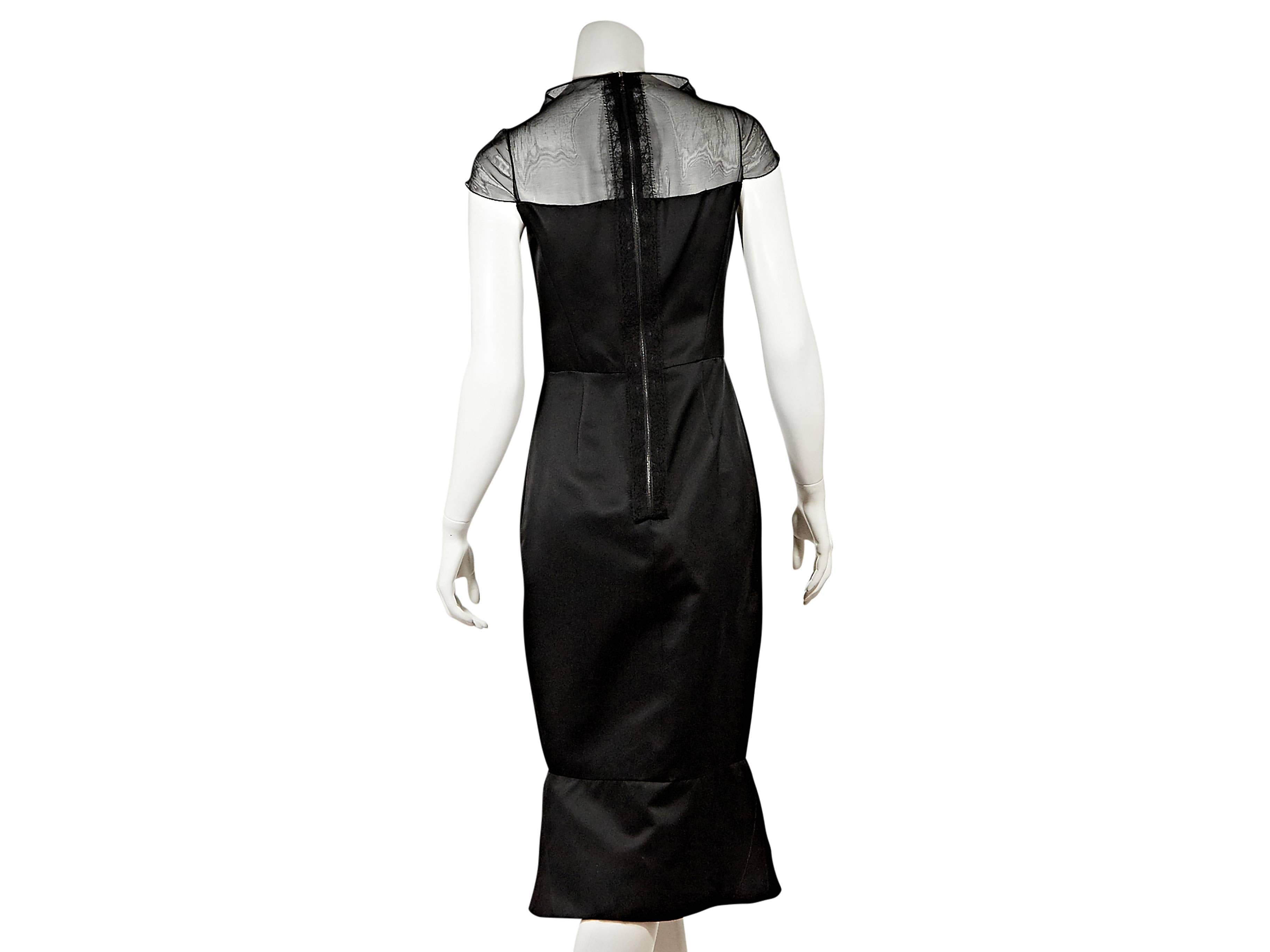 Black silk mermaid-hem dress by J. Mendel.  Wide mockneck.  Short sleeves.  Seaming creates a flattering silhouette.  Exposed back zip closure.