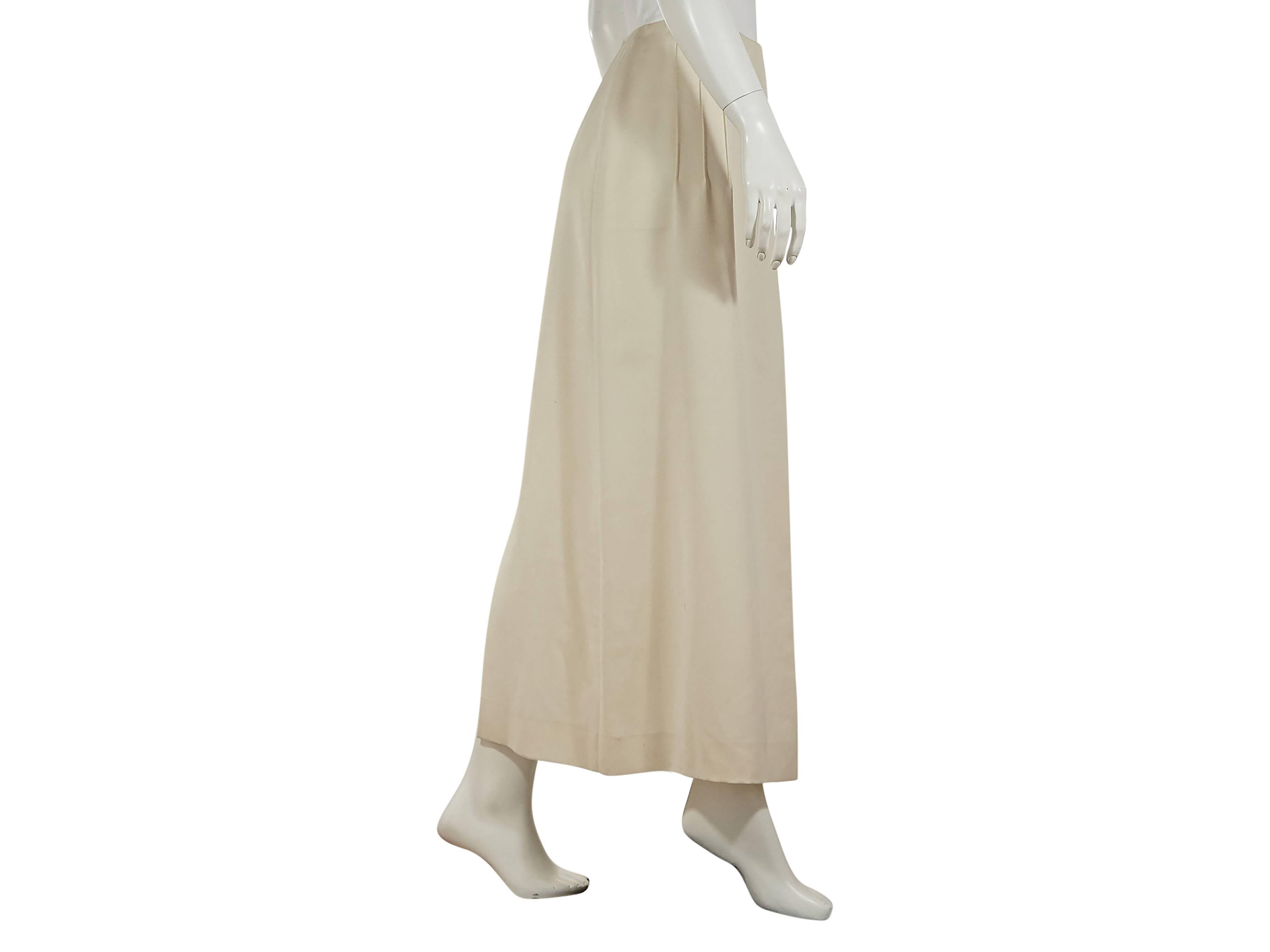 Ivory maxi skirt by Chanel.  Diagonally front and back pleats.  Side concealed zip closure.  Back hem vent. 