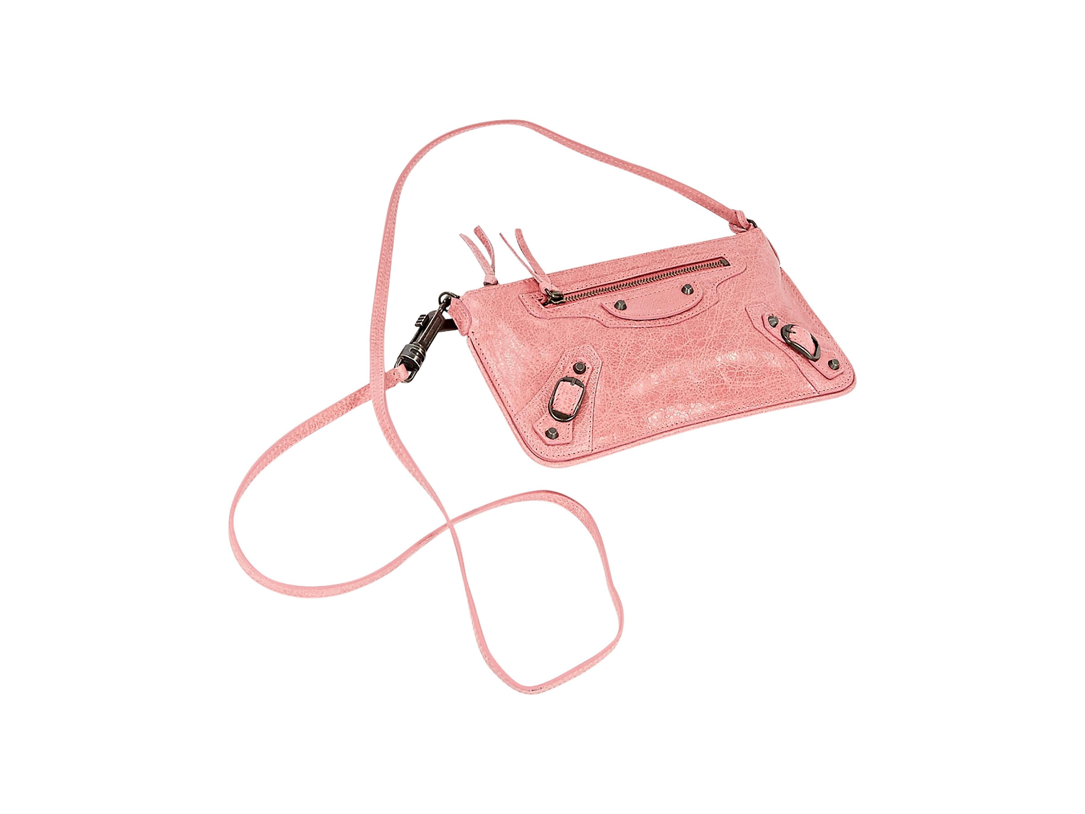 Pink leather crossbody bag by Balenciaga.  Detachable crossbody strap.  Top zip closure.  Front zip pocket.  Two buckle front accents.  Black hardware.  9