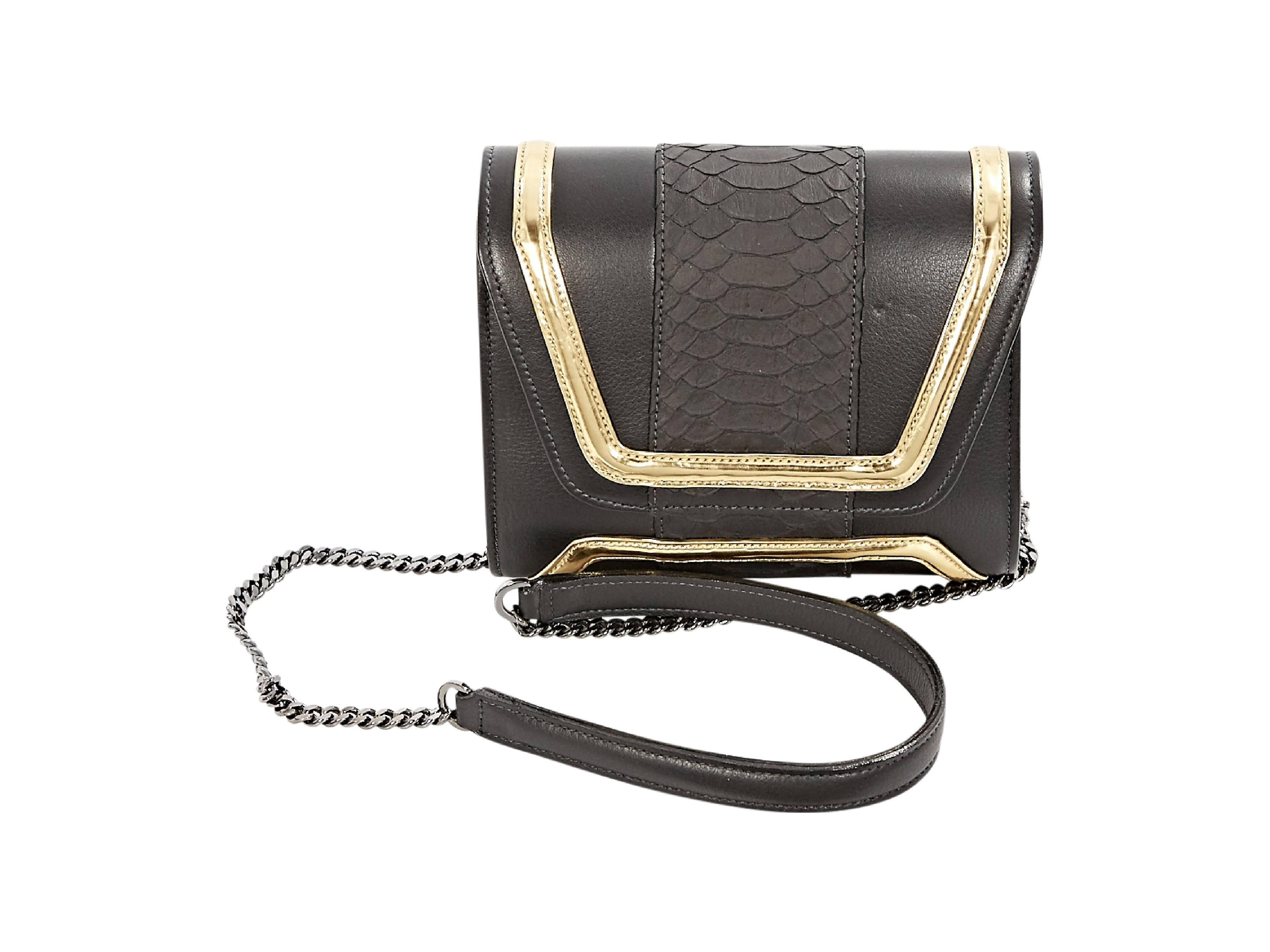 Black and gold leather crossbody bag by Yliana Yepez.  Snake-embossed center panel.  Tuck-away chain crossbody strap.  Front flap.  Lined interior with inner zip pocket.  Silvertone hardware.  7.5