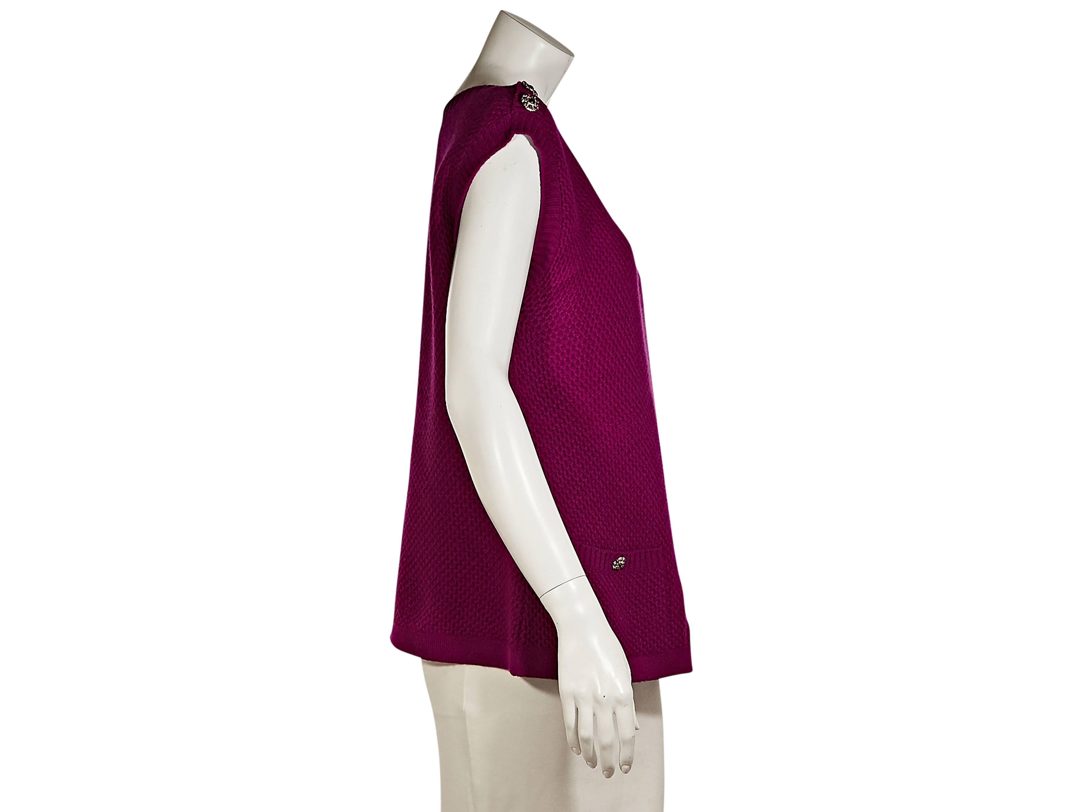 Magenta knit sweater top by Chanel.  Accented with embellishments. Scoopneck.  Cap sleeves.  Waist patch pockets.  Pullover style.  