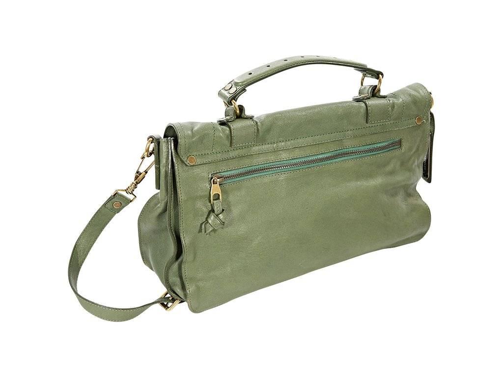 Product details: Green leather PS 1 satchel by Proenza Schouler. Detachable, adjustable crossbody strap. Top carry handle. Front flap with double strap details. Flip-lock closure. Lined interior with inner zip pocket. Back exterior zip pocket. 13
