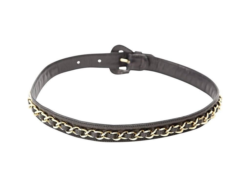 Product details:  Black leather belt by Chanel.  Accented with a chainlink.  Adjustable buckle closure.  Goldtone hardware.  Approximately 32
