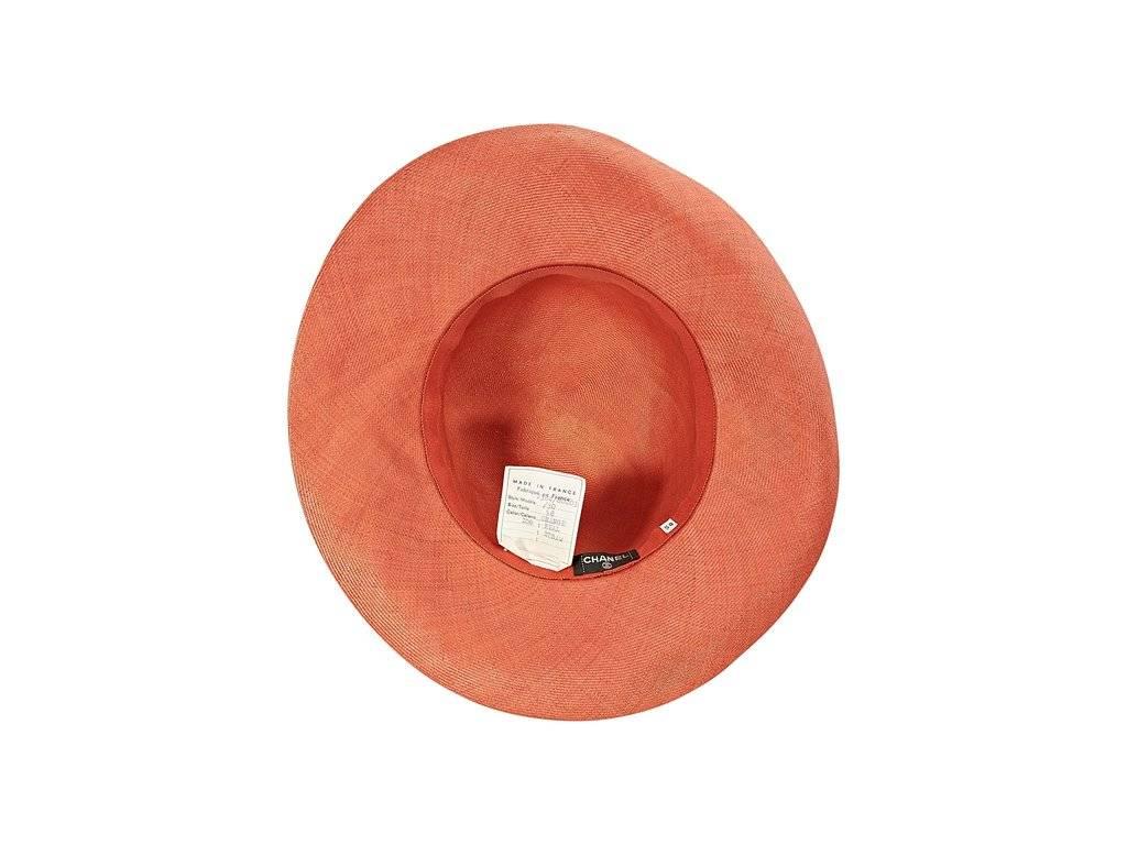 Product details:  Orange straw hat by Chanel.  Black grosgrain trim with a bow.
Condition: Excellent. 