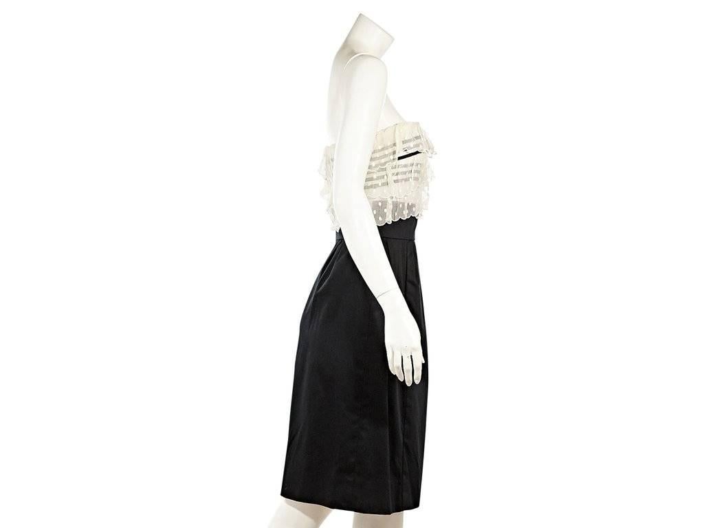 Product details:  ﻿Black and white strapless dress by Chanel.  Tiered scalloped ruffles over striped bodice.  Banded waist.  Pleats taper off waist.  Concealed back zip closure.  
Condition: Excellent.  