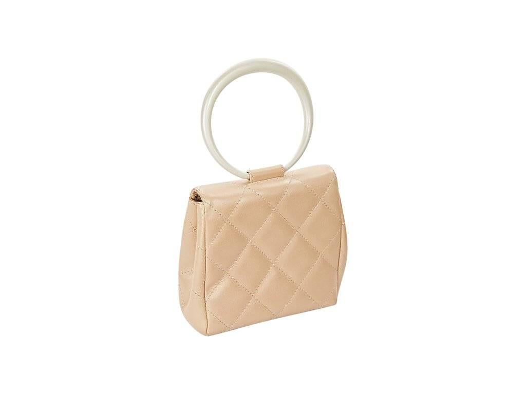 Product details:  Tan quilted leather evening bag by Chanel.  Top ring handle.  Front flap with twist-lock closure.  Leather lined interior with inner zip and slide pockets.  Silvertone hardware.  5.5