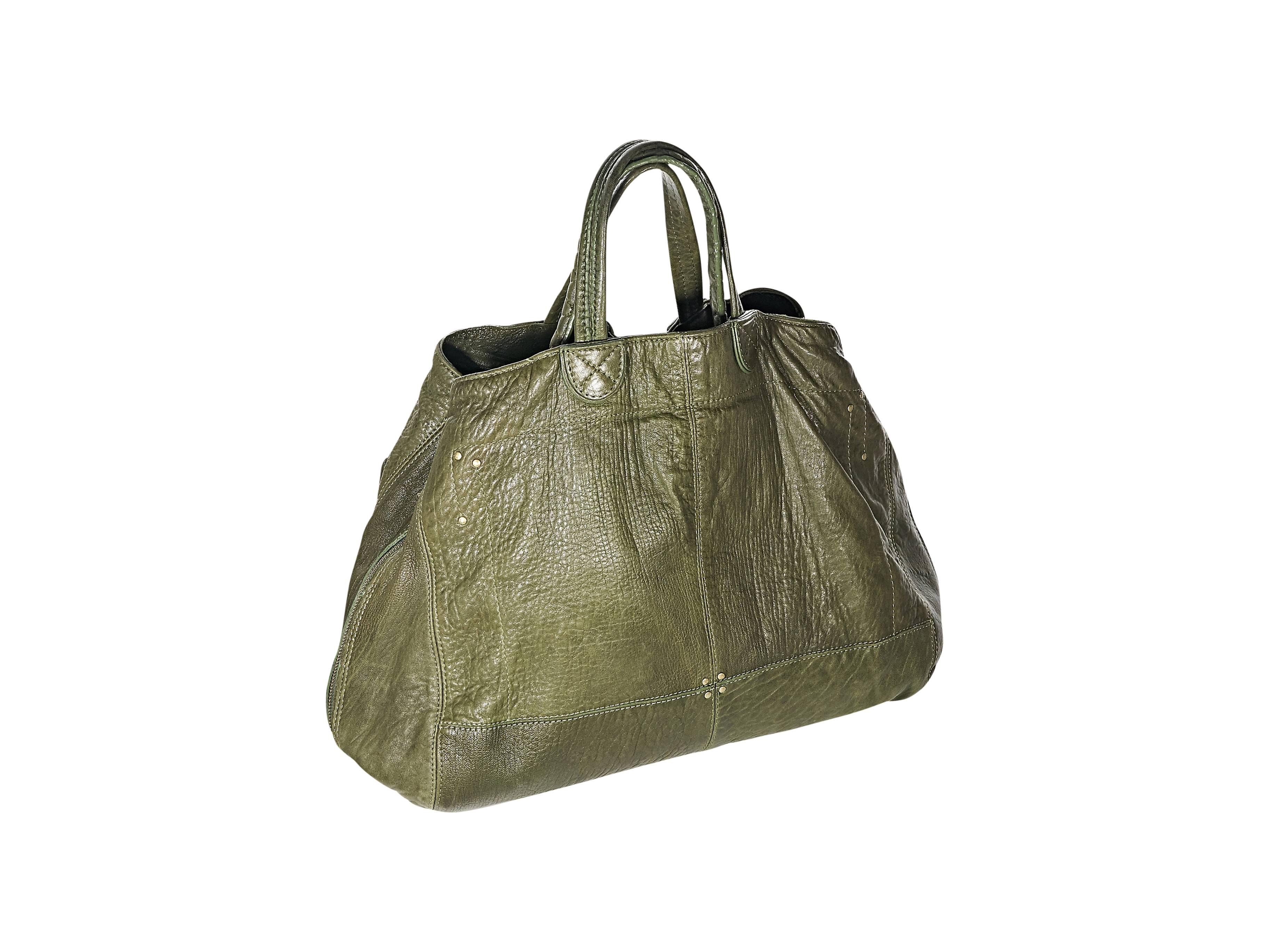 Product details: Green leather Jean Paul tote bag by Jerome Dreyfuss. Dual carry handles. Front zip pockets. Expandable zip sides. Double snap closure. Lined interior with inner pockets and attached flashlight. Goldtone hardware. 17