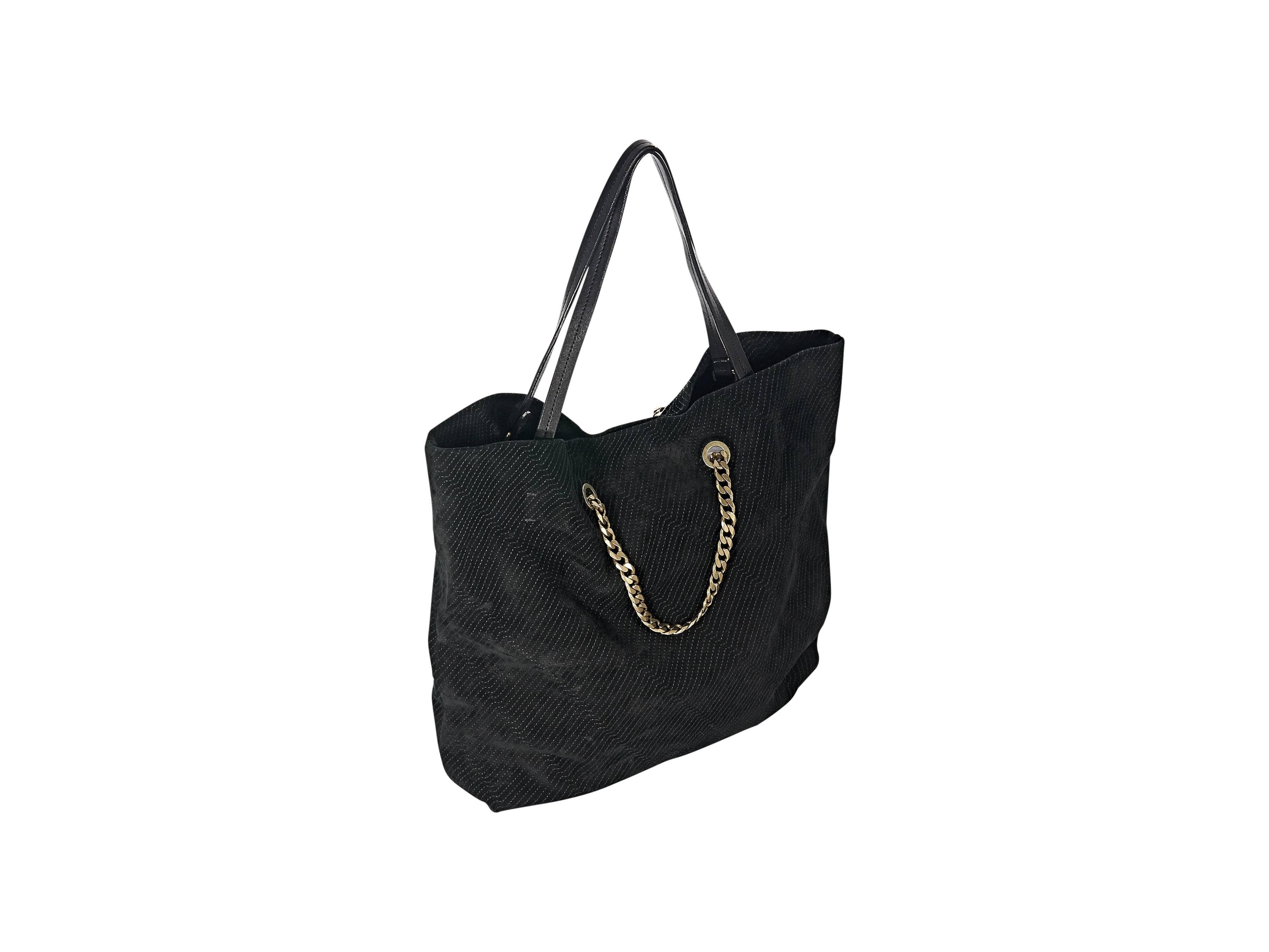Product details: Black suede topstitched Carry Me tote bag by Lanvin. Front chain accent. Dual shoulder straps. Lined interior with inner slide and zip pockets. Goldtone hardware. Dust bag included. 14