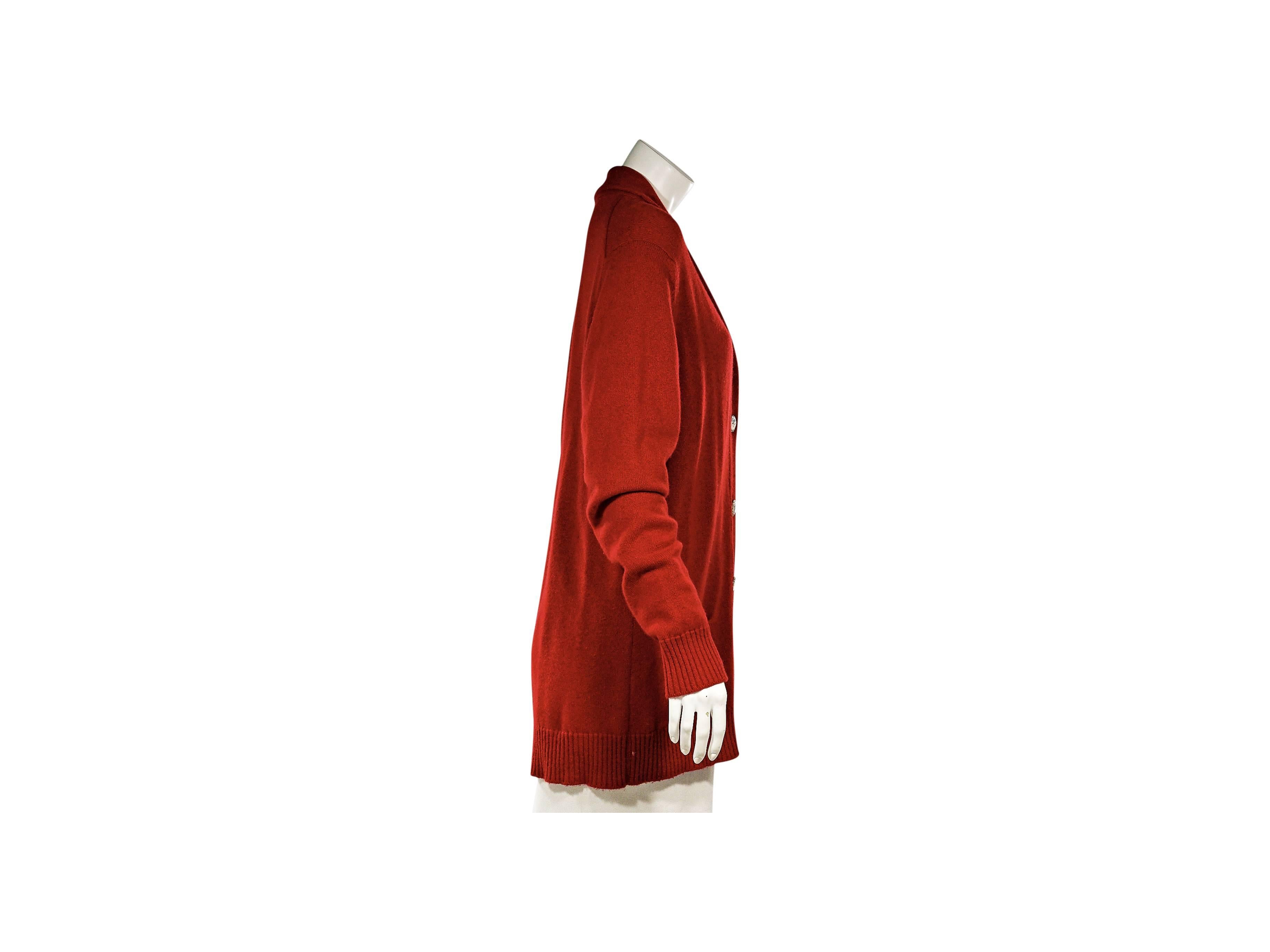 Product details:  ﻿Red oversized cashmere cardigan by Chanel.  Long sleeves.  Shawl collar.  Button-front closure.  Front patch pockets.  Ribbed cuffs and hemline.  
Condition: Excellent. 