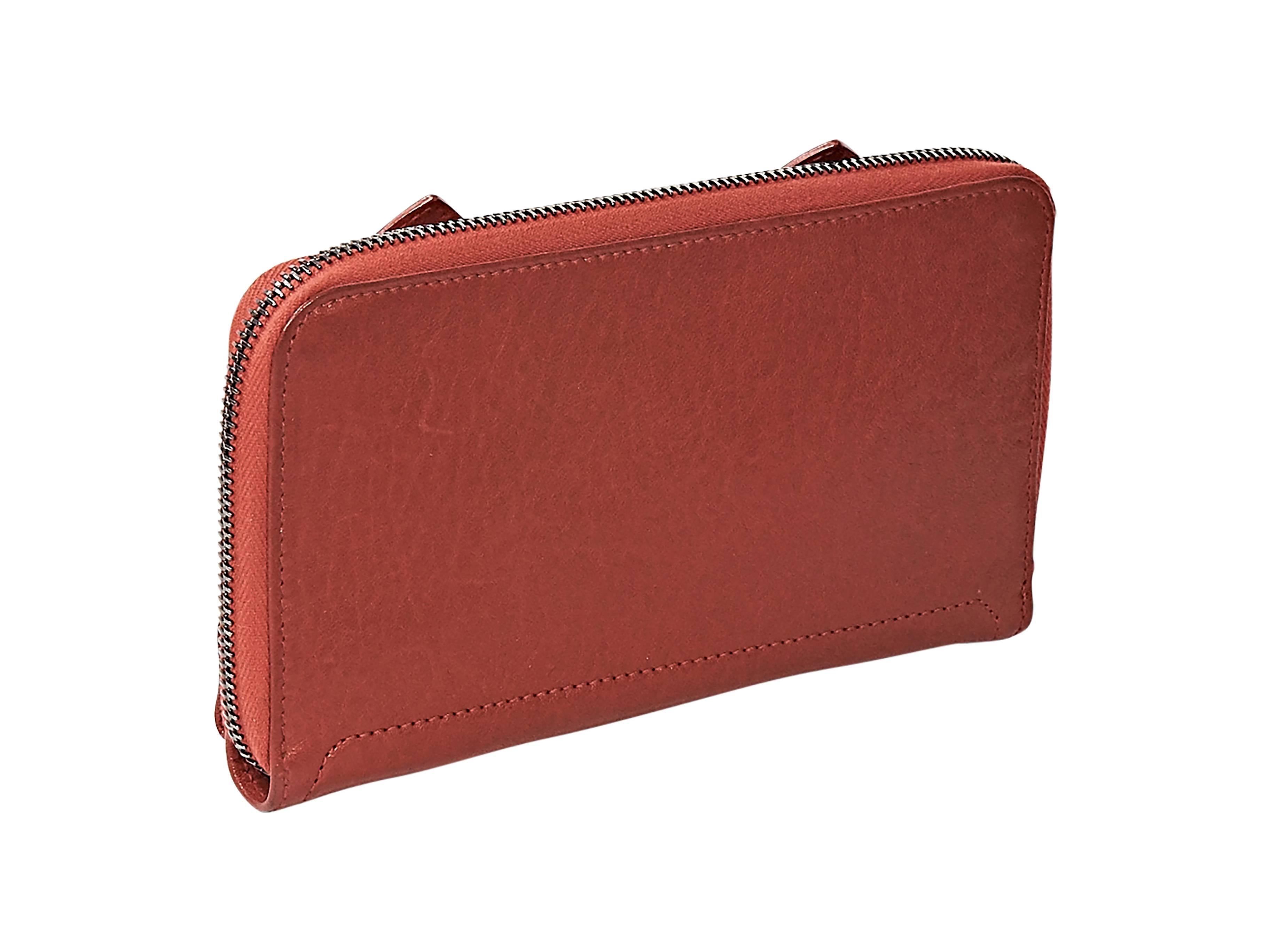 Product details:  Red leather PS1 wallet by Proenza Schouler.  Front flap with snap closure and belted straps.  Zip-around closure.  Multiple credit card slots and coin pouch.  ﻿7.25