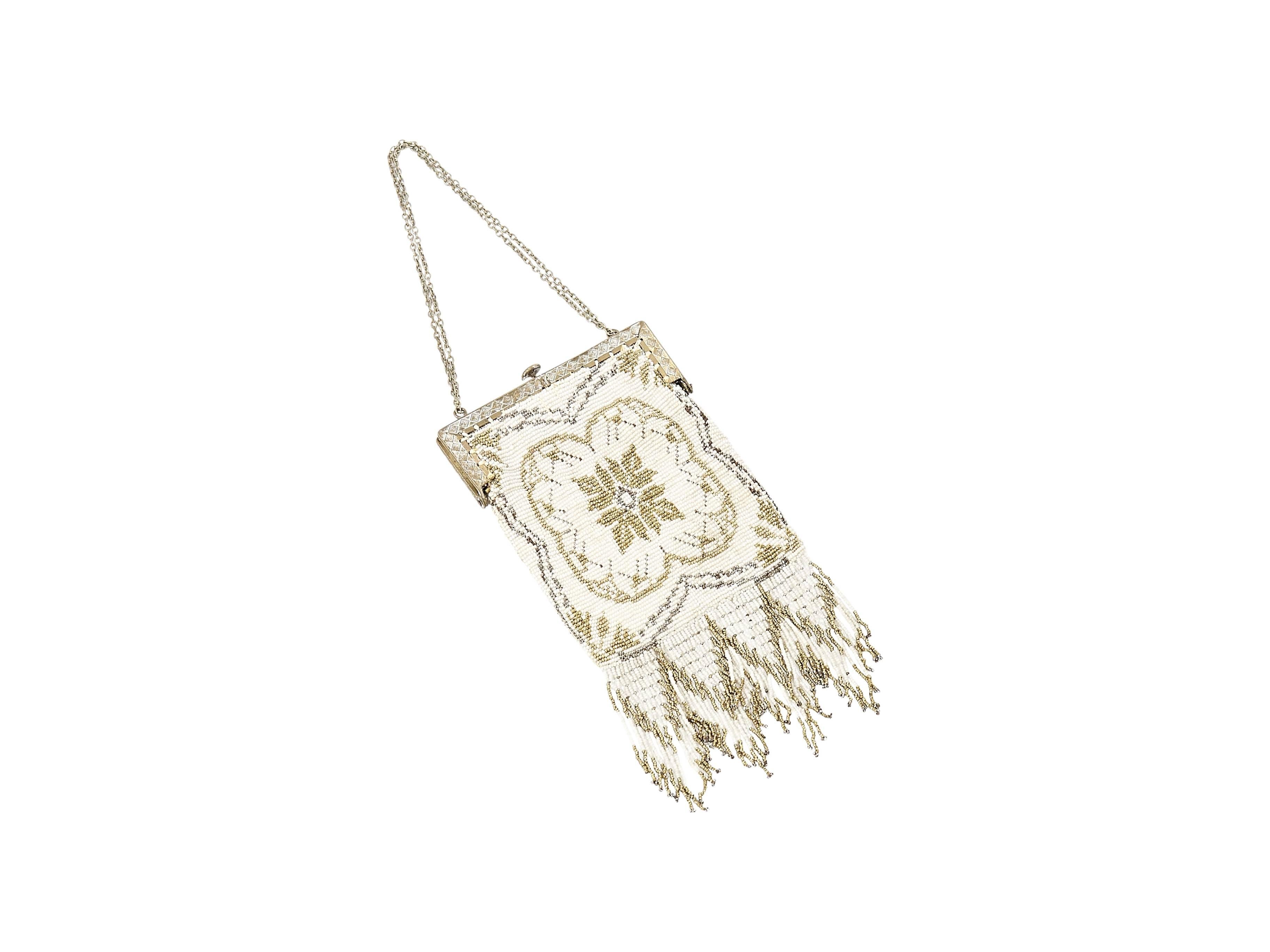 Product details:  Intricate ivory, gold and silver beaded vintage clutch by Whiting & Davis.  Circa 1920s.  Tuck-away chain strap.  Top push-lock closure.  Lined interior.  Chevron-like beaded fringe.  4
