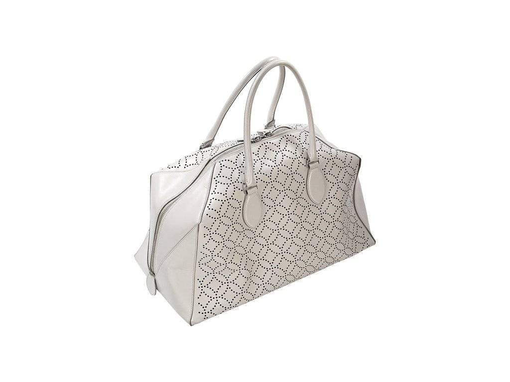 Product details:  Grey laser cut leather tote bag by Alaia.  Top carry handles.  Double top zip closure.  Inner detachable attached mirror.  Protective metal feet.  Silvertone hardware.  17.5"L x 9"H x 8.5"D.ï»¿
Condition:
