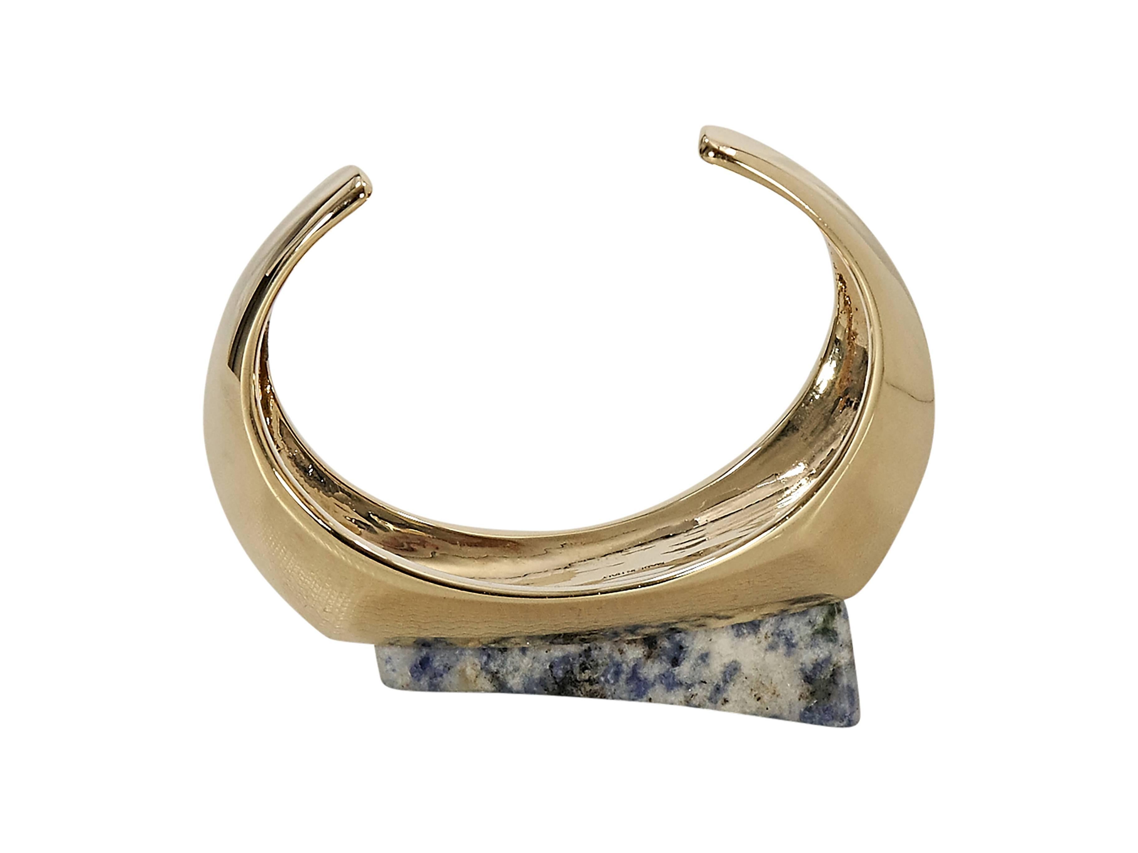 Product details:  ﻿Goldtone Bettina cuff by Chloe.  Asymmetrical band.  Triangular stone accent.  
Condition: Excellent. 