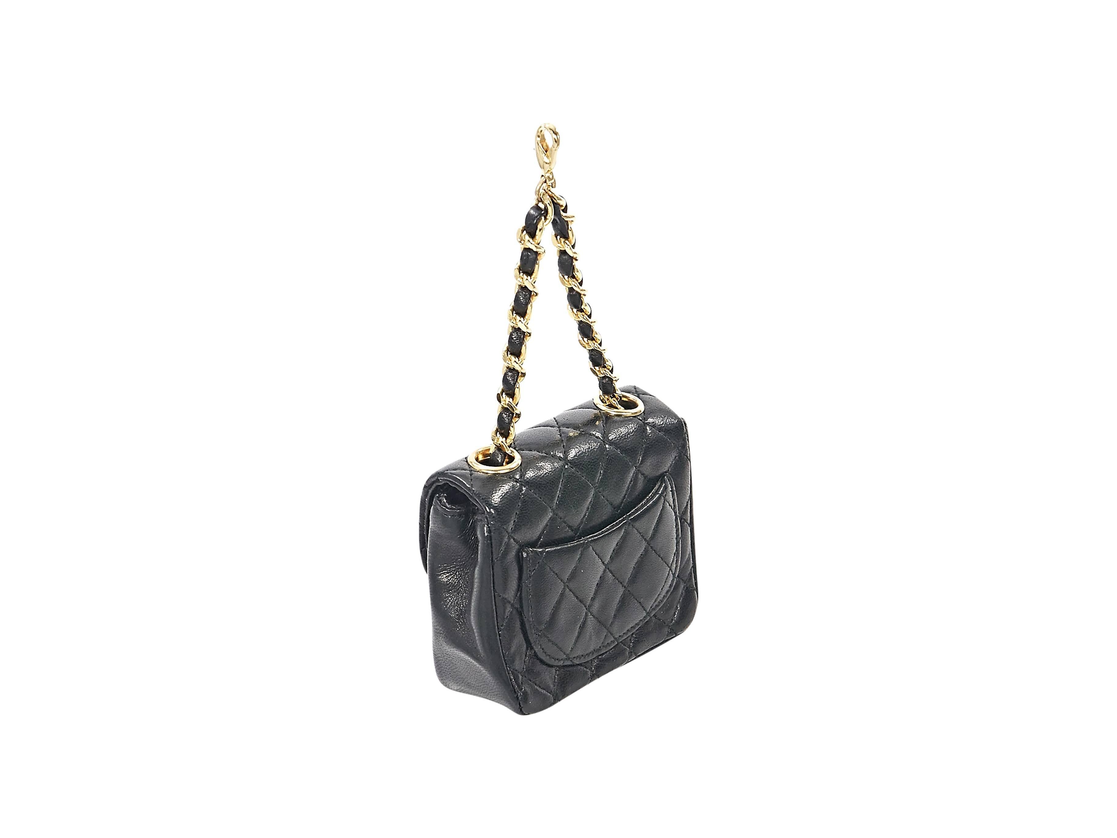 Product details:  Black quilted leather micro mini bag by Chanel.  Leather woven chain strap with lobster clasp closure.  Front flap.  Hidden magnetic snap closure.  Leather lined interior.  Back exterior slide pocket.  3.5