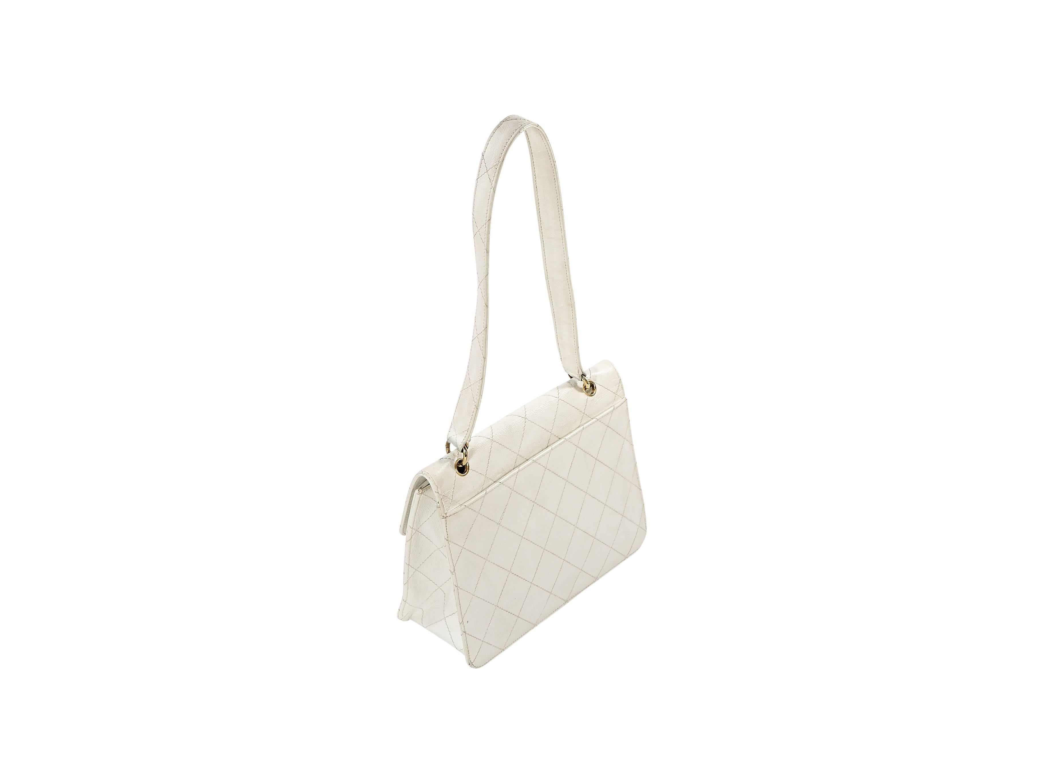 Product details:  Vintage white leather shoulder bag by Chanel.  Topstitched quilted design.  Shoulder strap.  Twist-lock logo closure.  Leather lined interior with inner zip and slide pockets.  Goldtone hardware.  Authenticity card included.  10