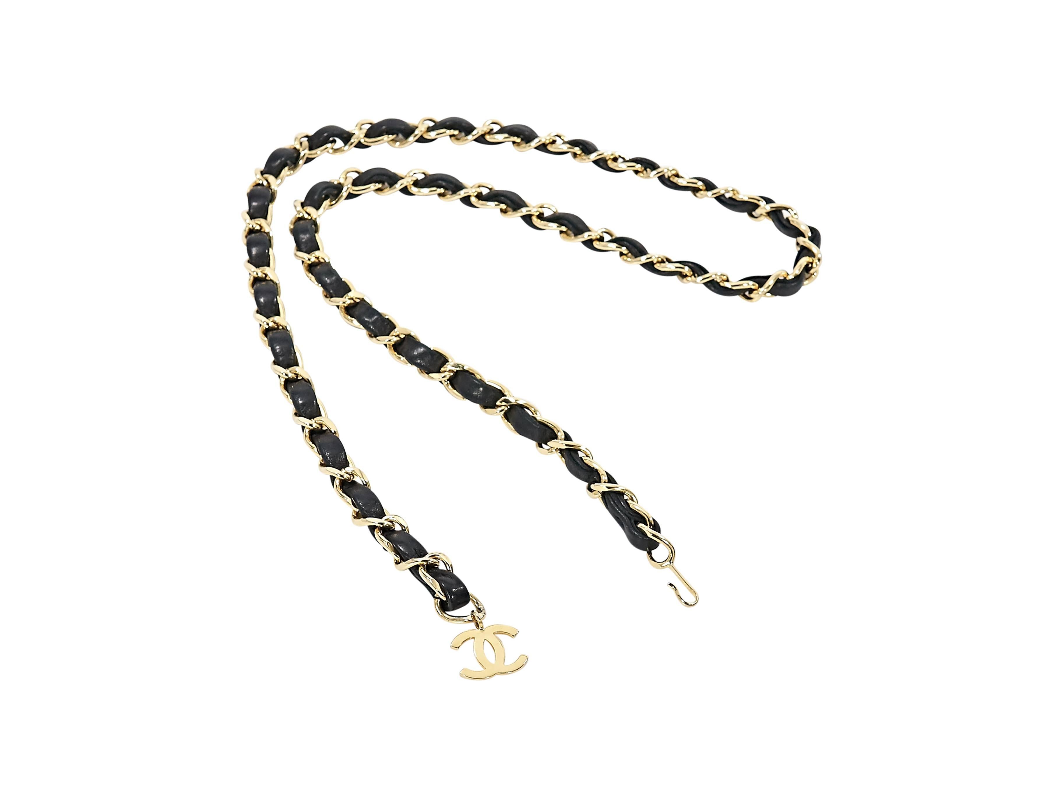 Product details: Black leather woven chain belt by Chanel. Hanging logo charm. Hook closure. 38