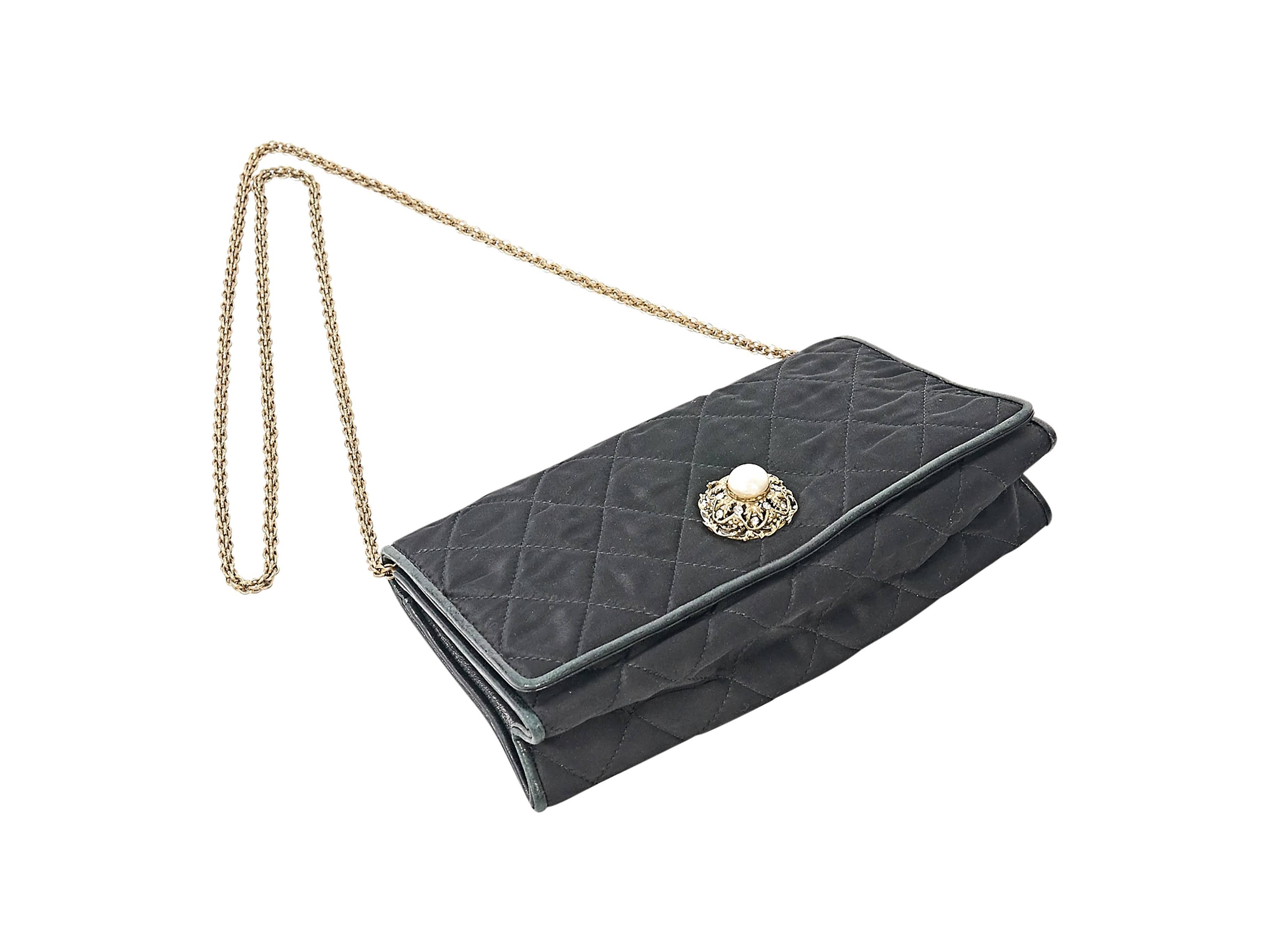Product details:  Vintage black quilted flap bag by Chanel.  Accented with a pearl detail.  Chain crossbody strap.  Concealed magnetic snap closure.  Lined interior with inner zip pocket.  Goldtone hardware.  8.75"L x 4.5"H x 2.5"D. 