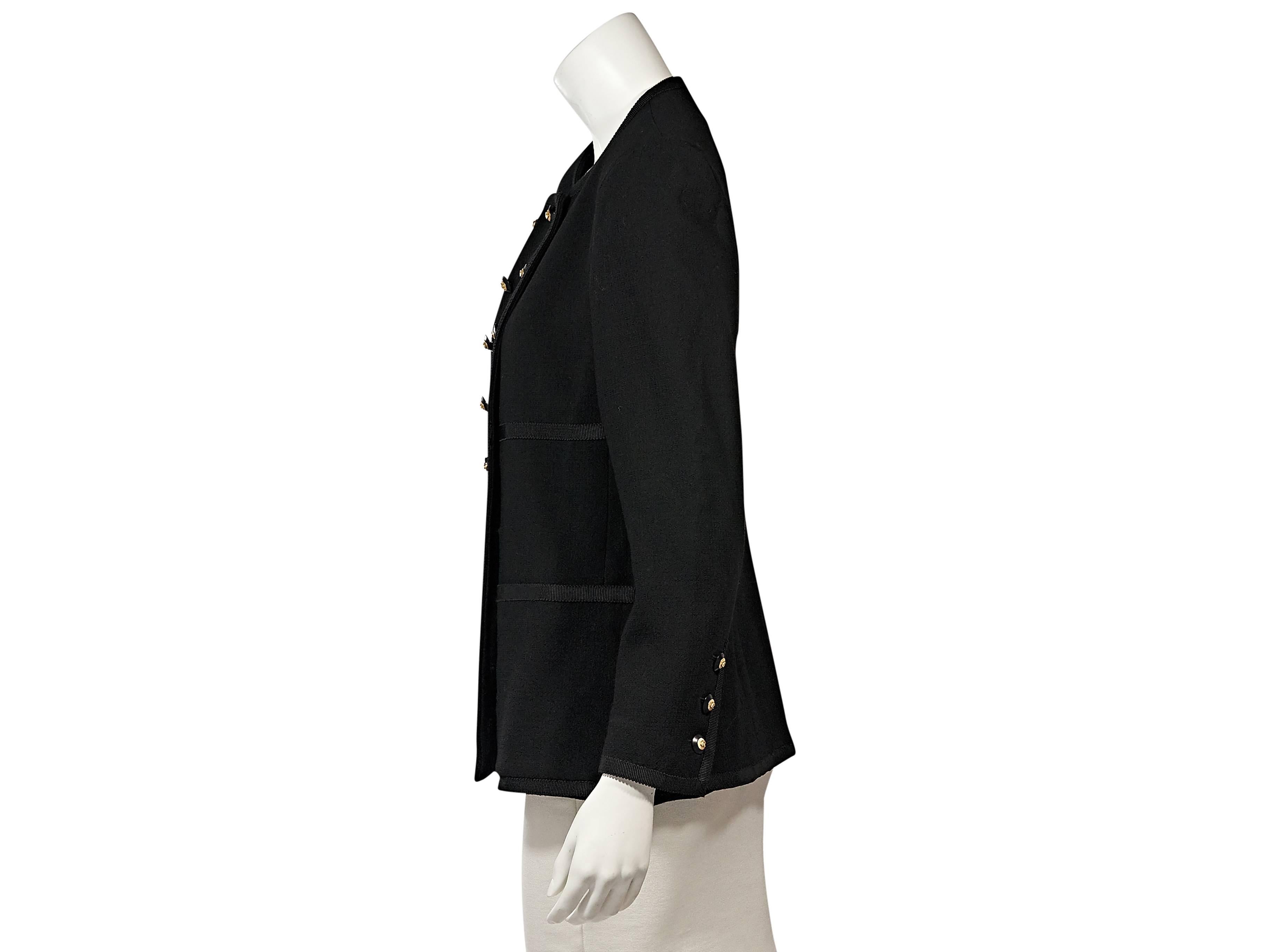 Product details:  Vintage black double-breasted jacket by Chanel.  Trimmed with grosgrain ribbon.  Crewneck.  Long sleeves.  Three-button detail at cuffs.  Double-breasted button front.  Waist patch pockets.  
Condition: Very good. 