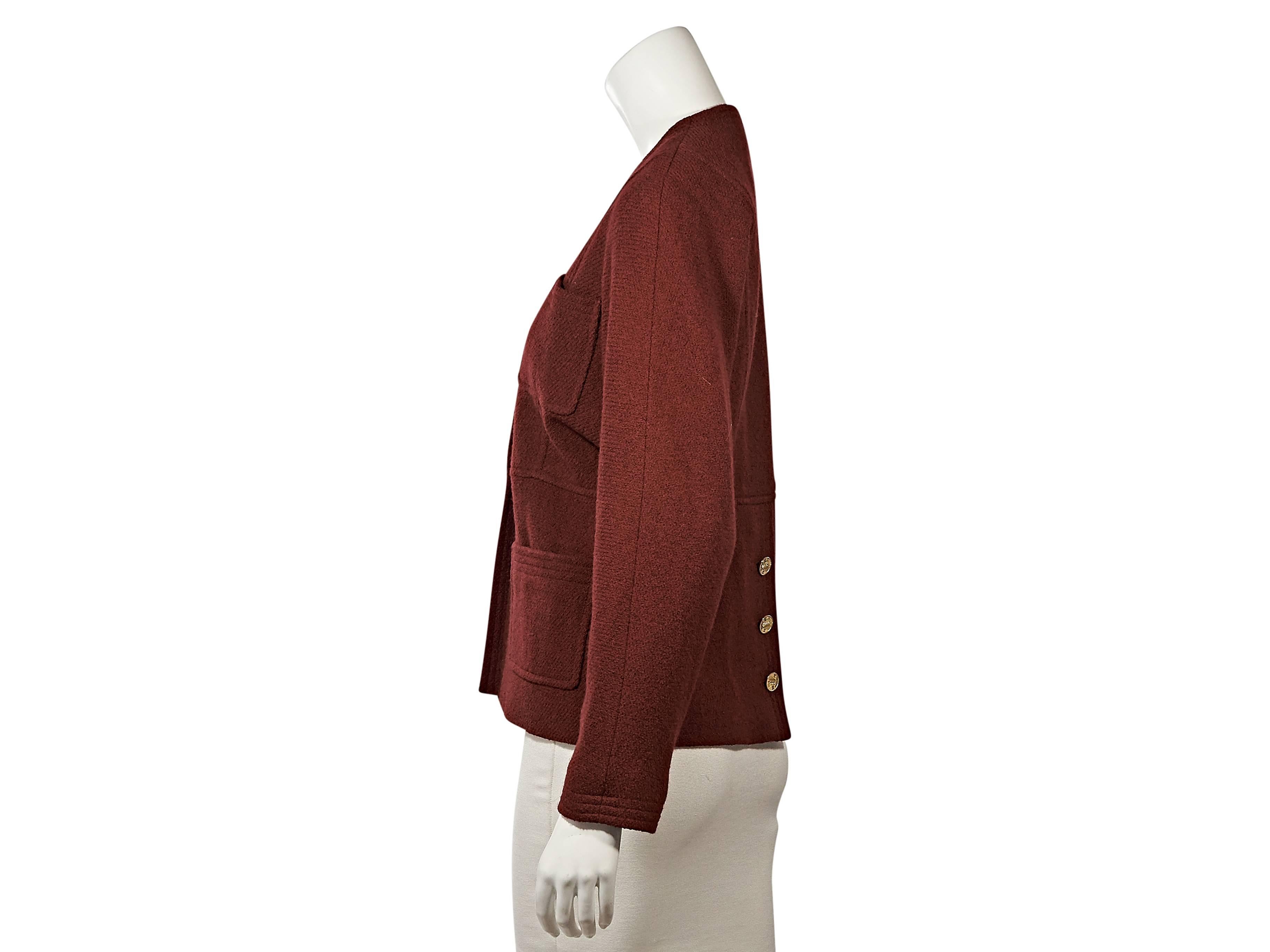 Product details:  Vintage red jacket by Chanel.  Crewneck.  Long sleeves.  Three-button detail at cuffs.  Concealed front closure.  Four front patch pockets.  Triple button back hem vent. 
Condition: ﻿Very good
