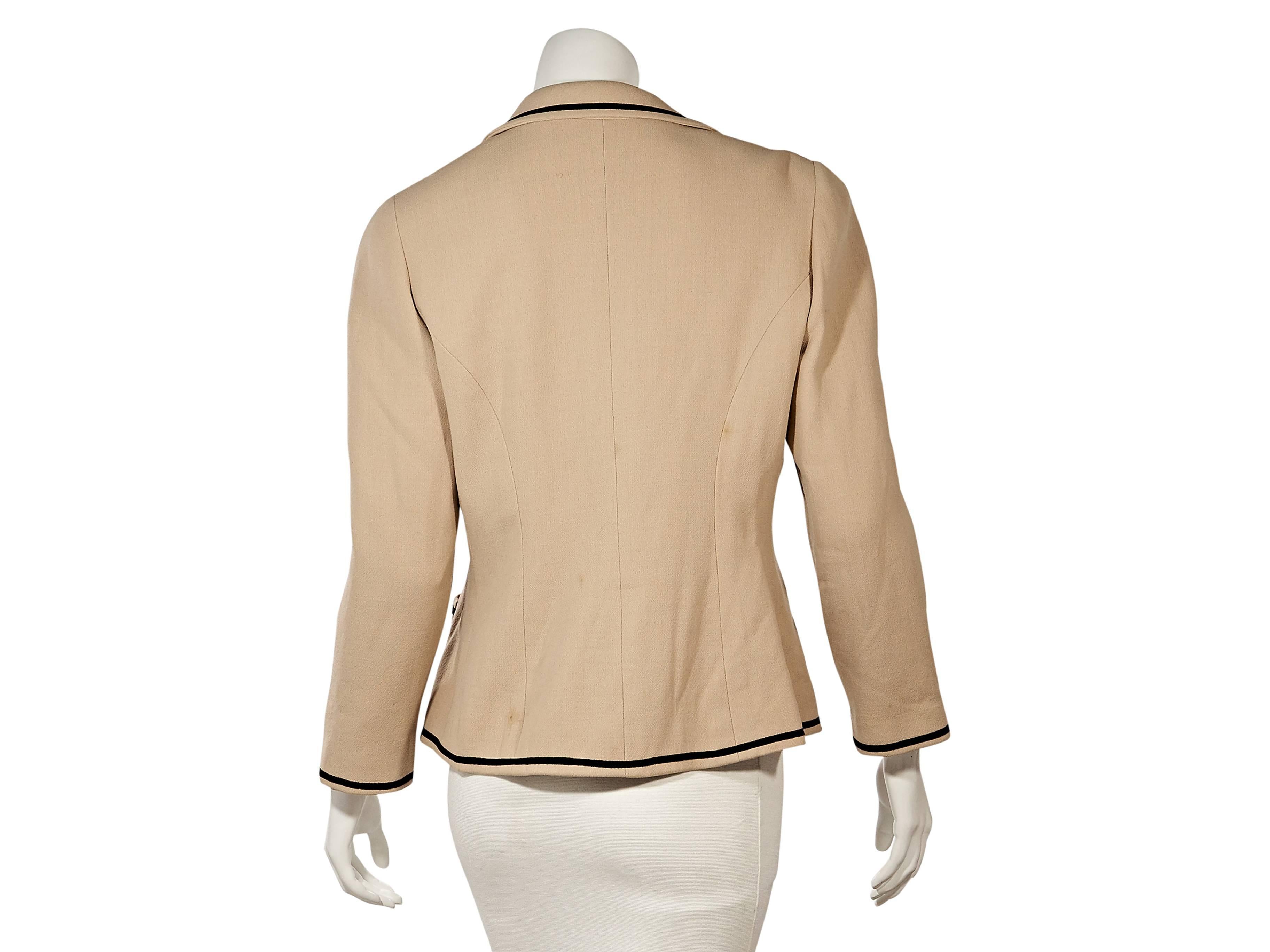 Product details:  Vintage tan blazer by Chanel.  Piped trim.  Rounded notched lapel.  Long sleeves.  Single button-front.  Waist patch pockets.  
Condition: Very good. 