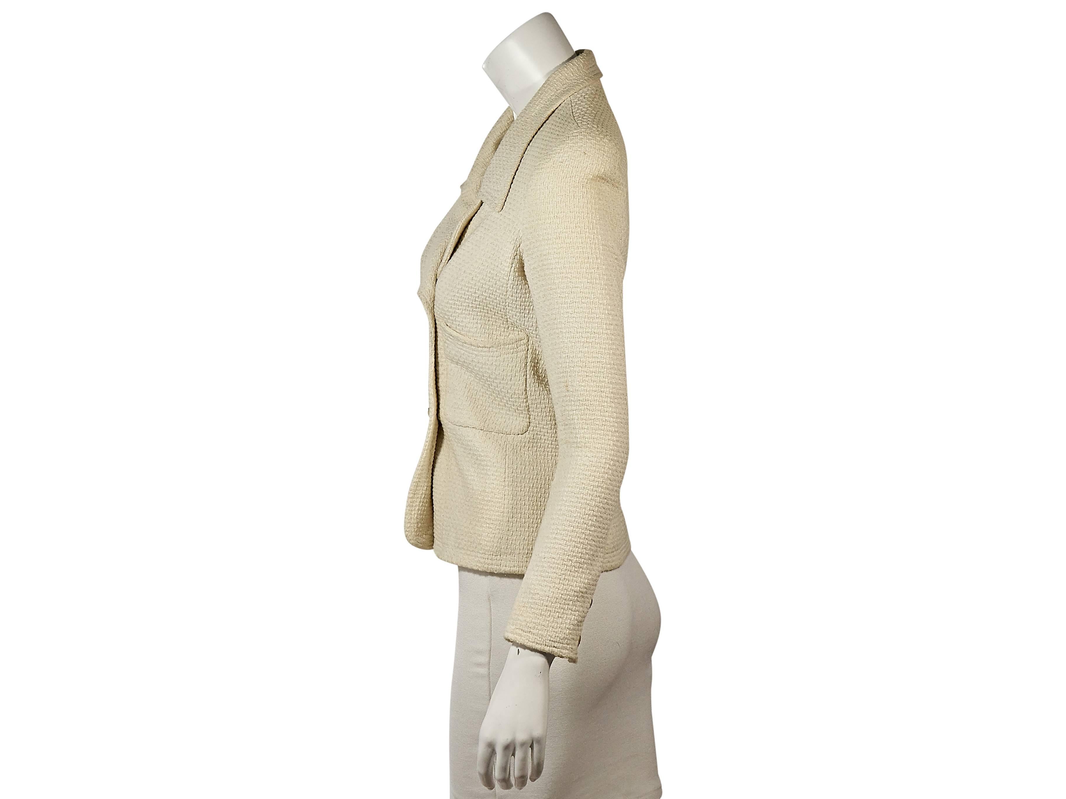 Product details: Vintage cream textured jacket by Chanel. Modified notched lapel. Bracelet-length sleeves. Two-button details at cuffs. Double-breasted button front. Front patch pockets. Lined. 
Condition: Very good. 