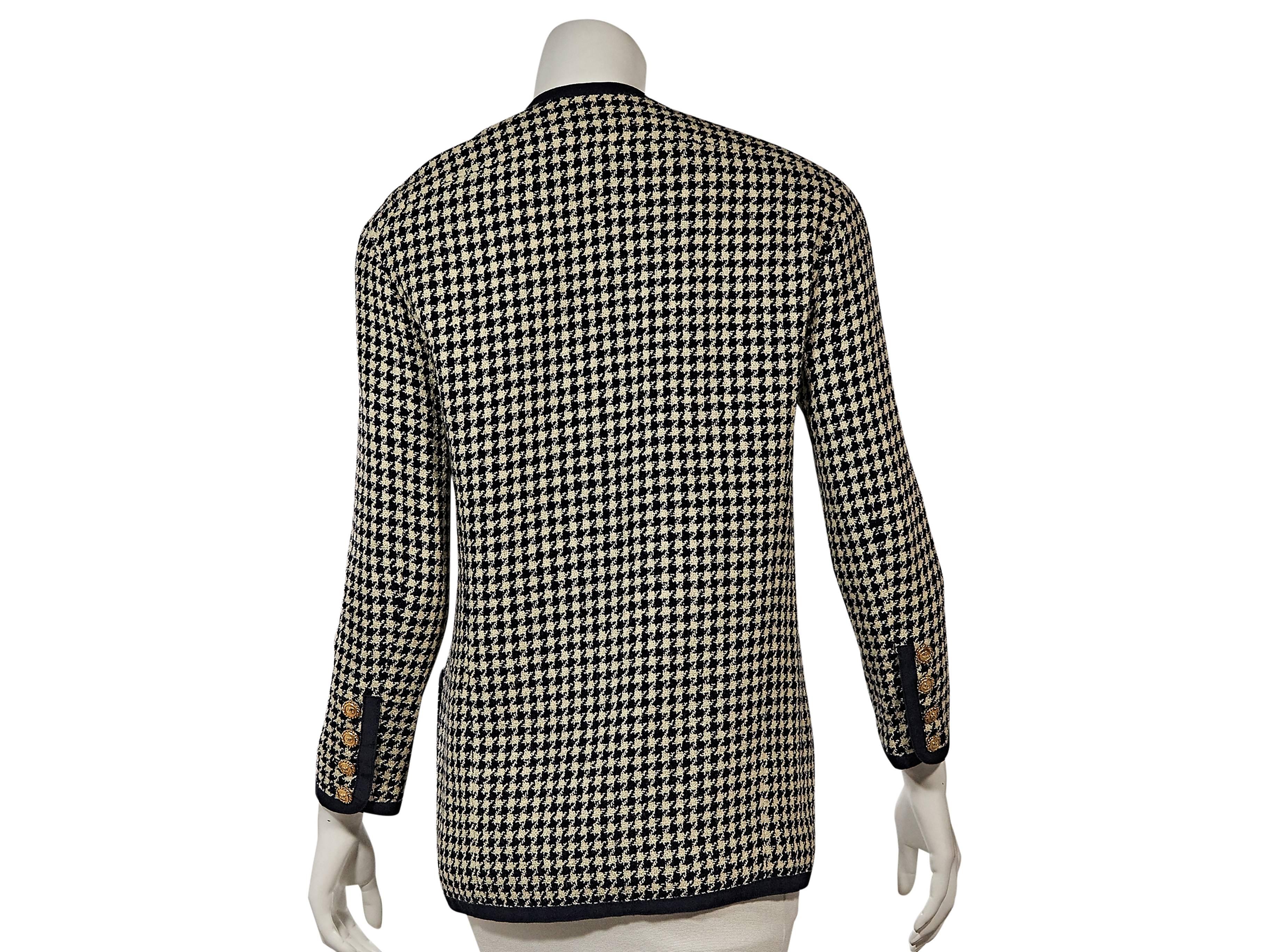 Product details: Vintage blue houndstooth jacket by Chanel. V-neck. Bracelet-length sleeves. Four-button detail at cuffs. Concealed front closure. Besom button-front pockets. 
Condition: Very good. 