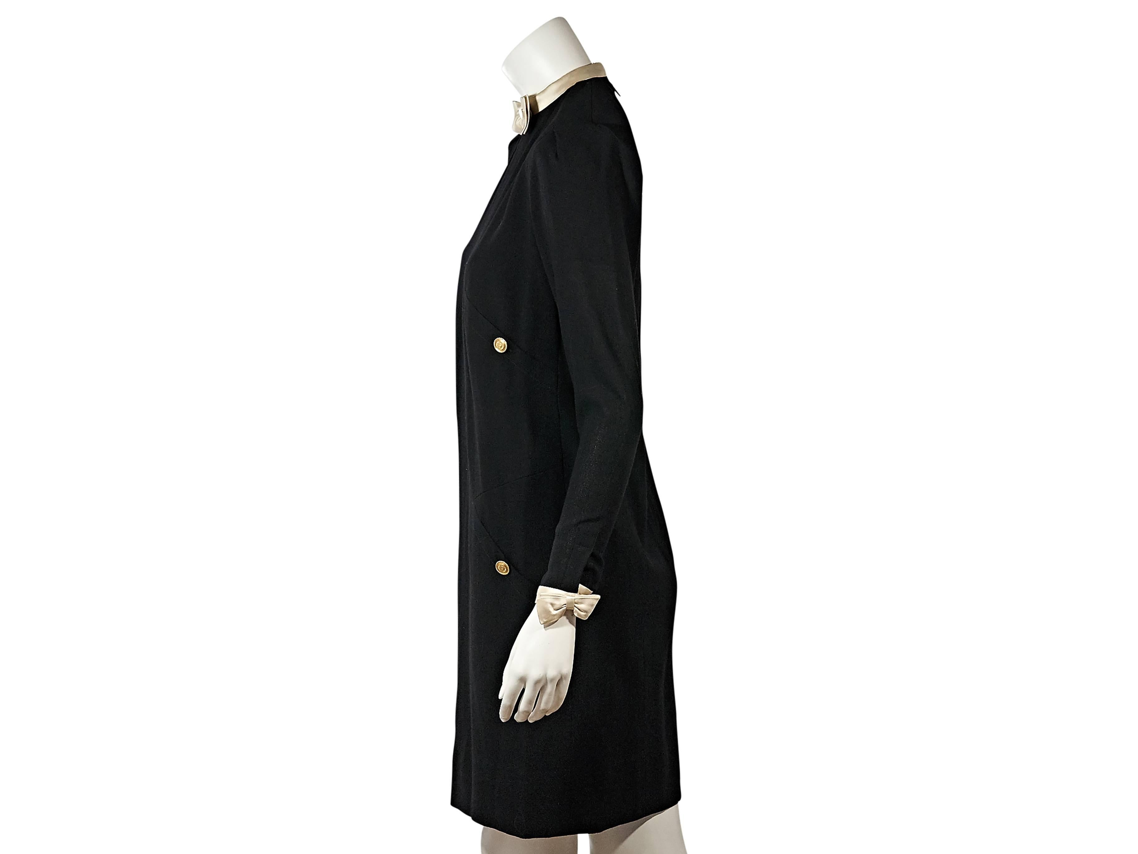Product details:  Vintage black dress by Chanel.  Crewneck accented with a bow.  Long sleeves.  Satin-trimmed cuffs with bow accents.  Concealed back zip closure.  
Condition: Very good. 

