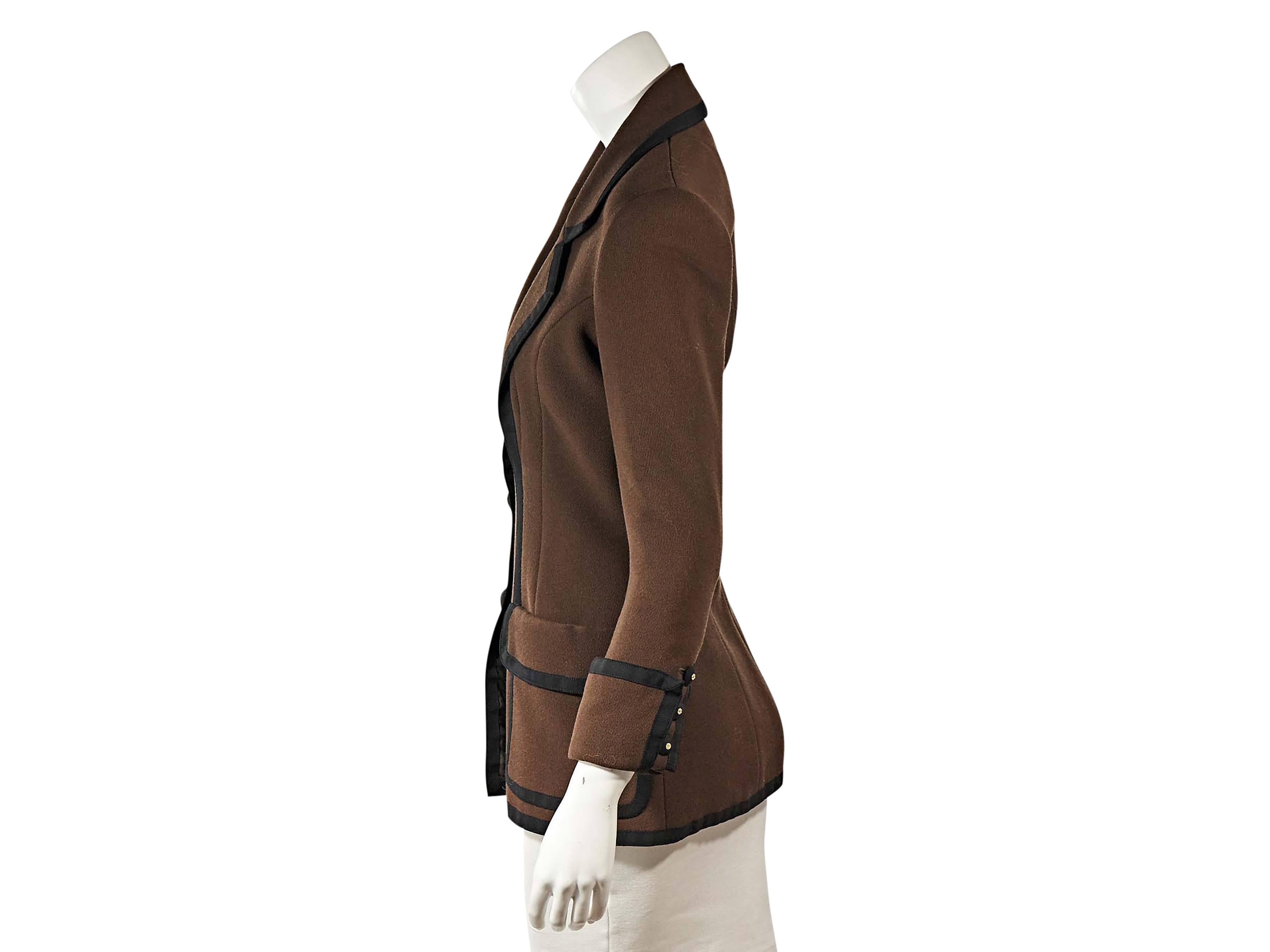 Product details: Vintage brown and black blazer by Chanel. Notched lapel. Three-quarter length sleeves. Triple-button detail at turn back cuffs. Button front closure. Flap patch pockets. Fitted seams at back. 
Condition: Very good. 