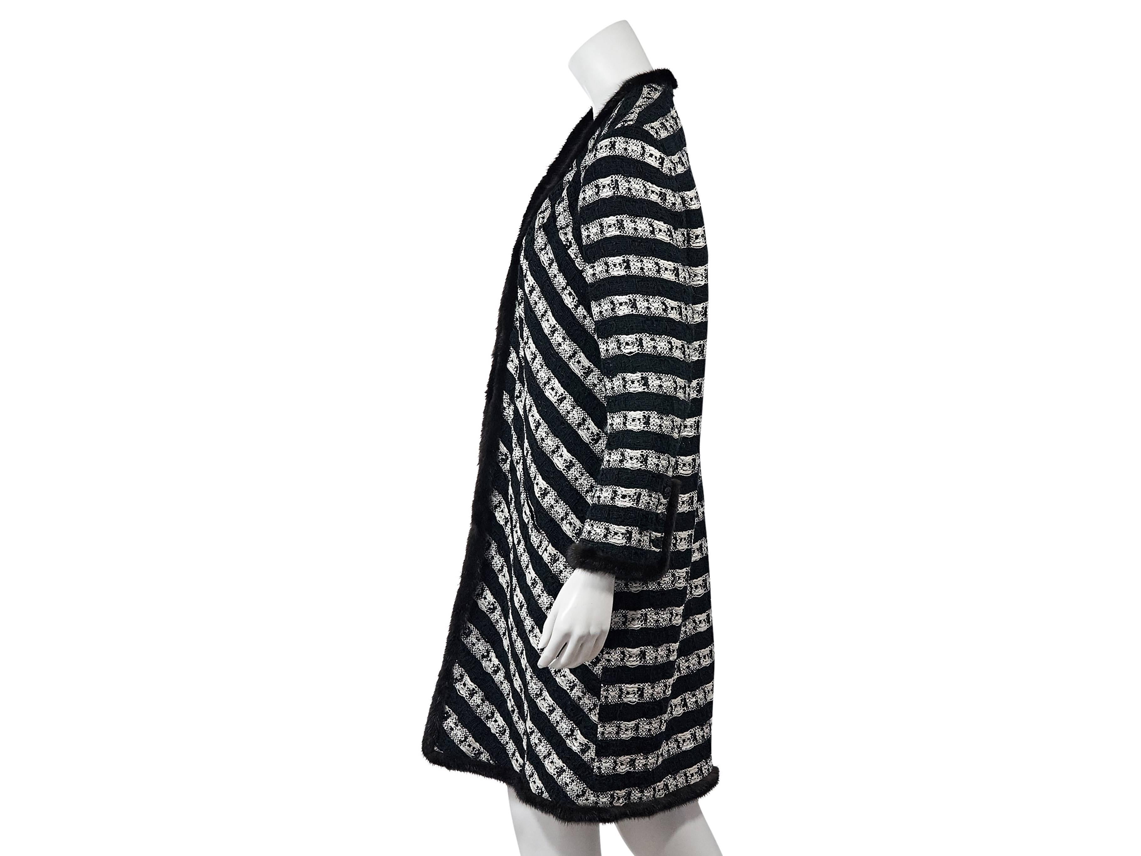 Product details:  Black and white boucle striped jacket by Chanel.  Trimmed with black mink fur.  V-neck.  Long sleeves.  Three-button detail at cuffs.  Concealed front closure. Marked size FR 46.
Condition: Excellent. 