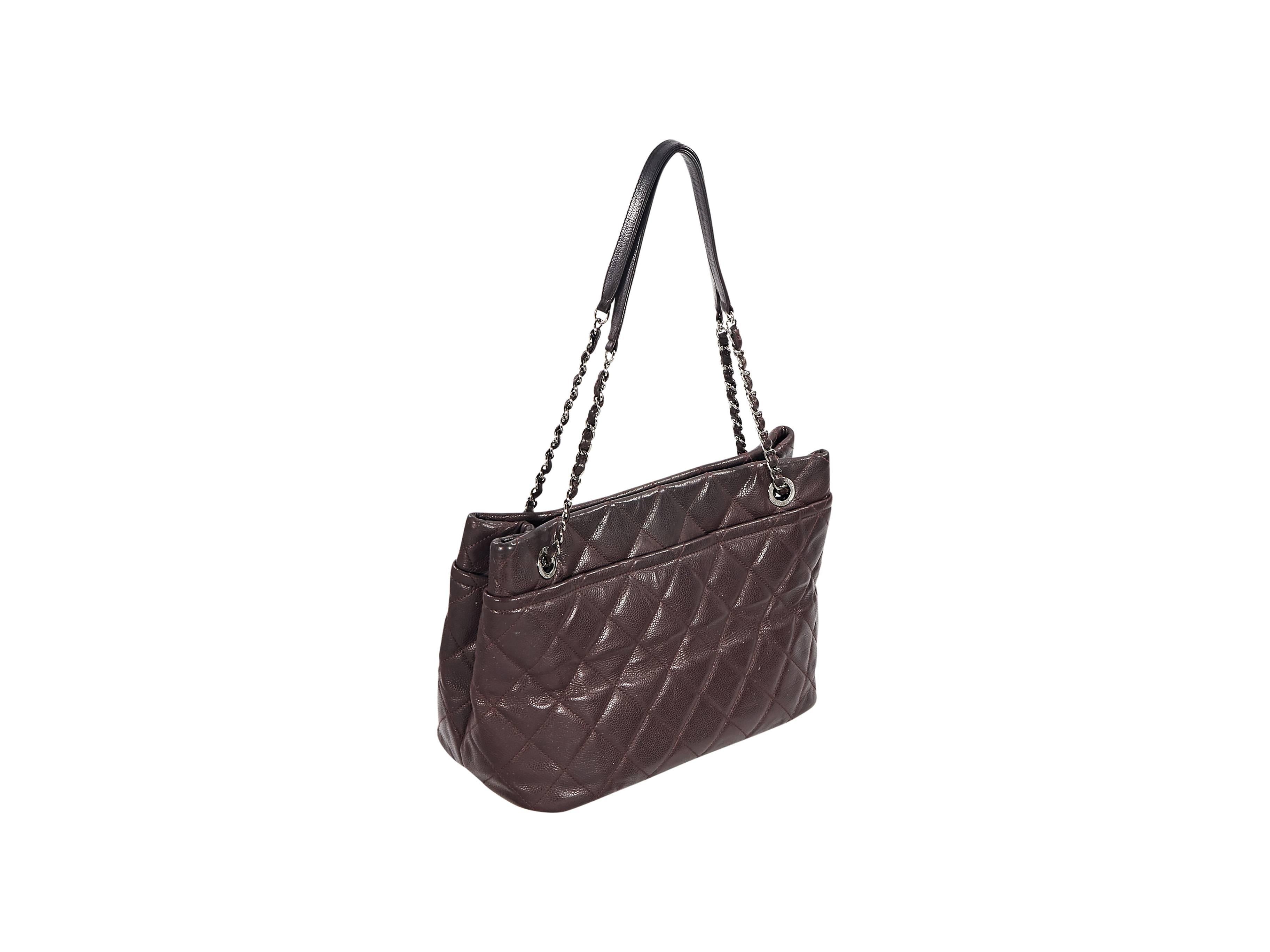 Product details:  Burgundy quilted caviar leather tote bag by Chanel.  Features oversized CC logo at front.  Dual shoulder straps.  Magnetic snap closure.  Lined interior with inner zip and slide pockets plus attached key strap.  Protective metal