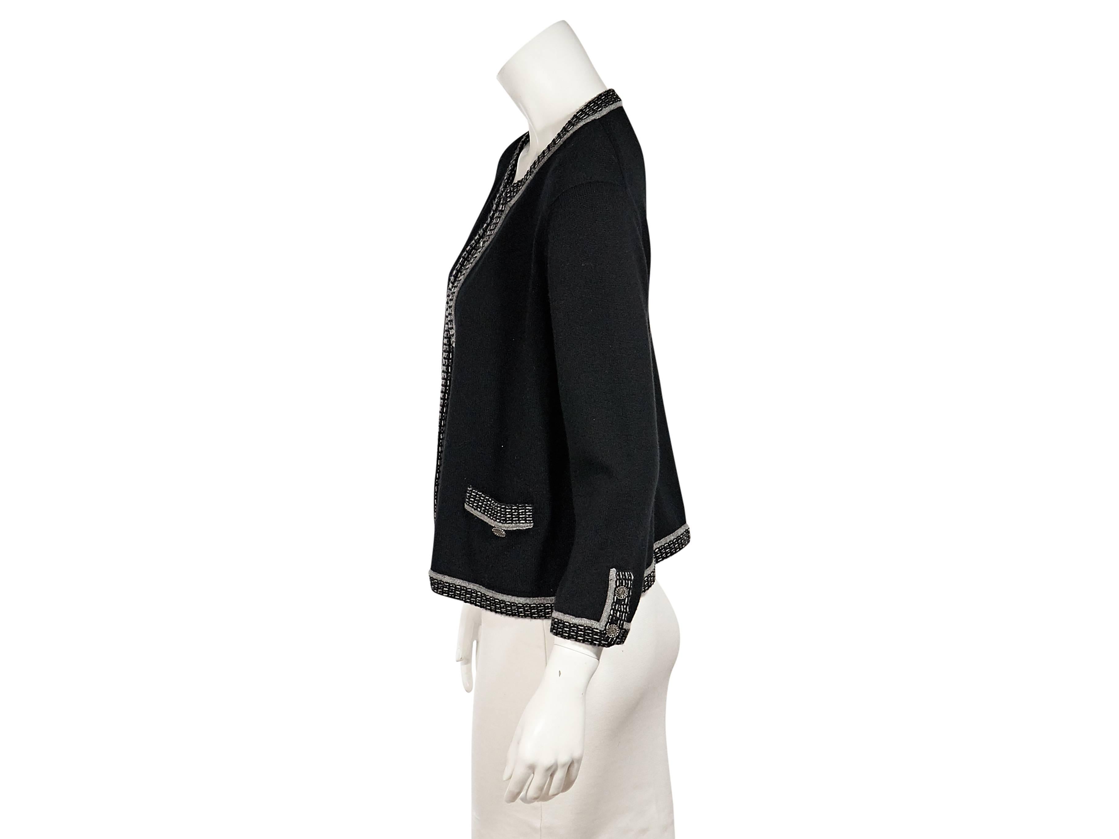 Product details:  Black cardigan with grey trim by Chanel.  Three-quarter length sleeves.  Open front.  Patch pockets at waist.  Label size FR 46. 
Condition: Very good. 
Est. Retail $ 1,248.00