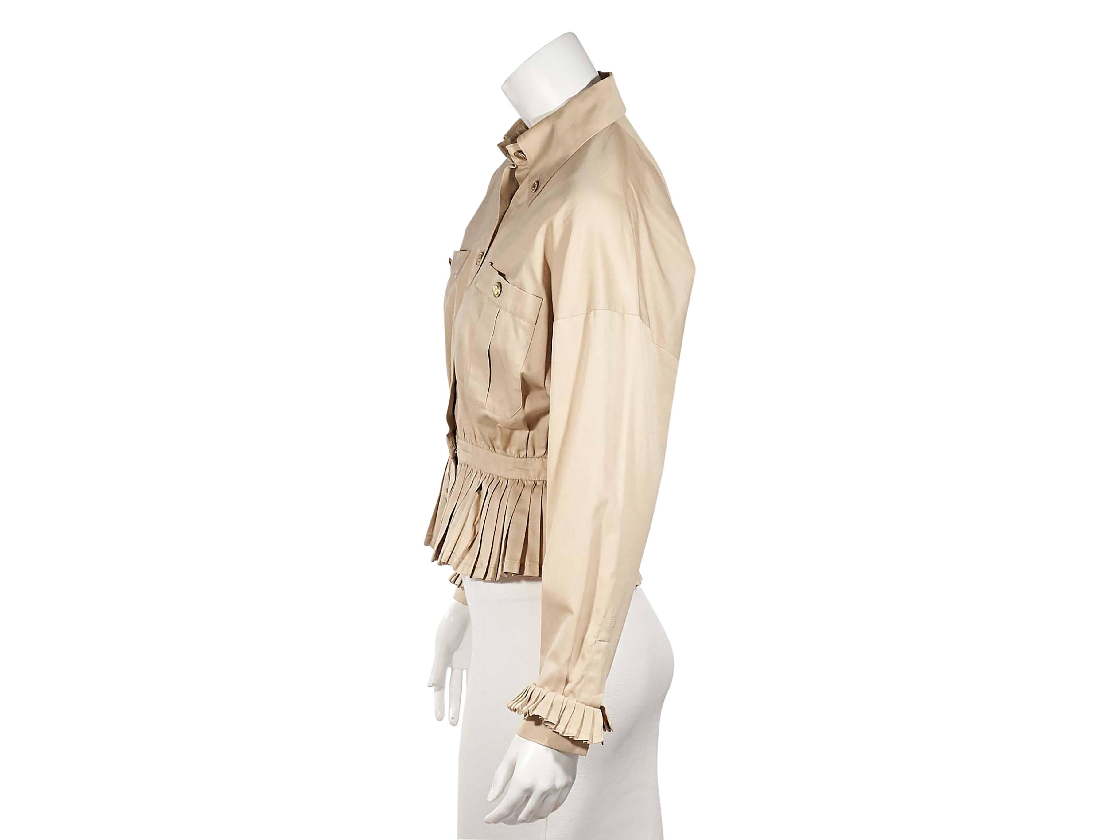 Product details:  Vintage tan peplum jacket by Chanel.  Button-down point collar.  Long dolman sleeves.  Ruffled detail at cuffs.  Button-front closure.  Chest button patch pockets.  Pleated peplum hem.   
Condition: Excellent. 
Est. Retail $
