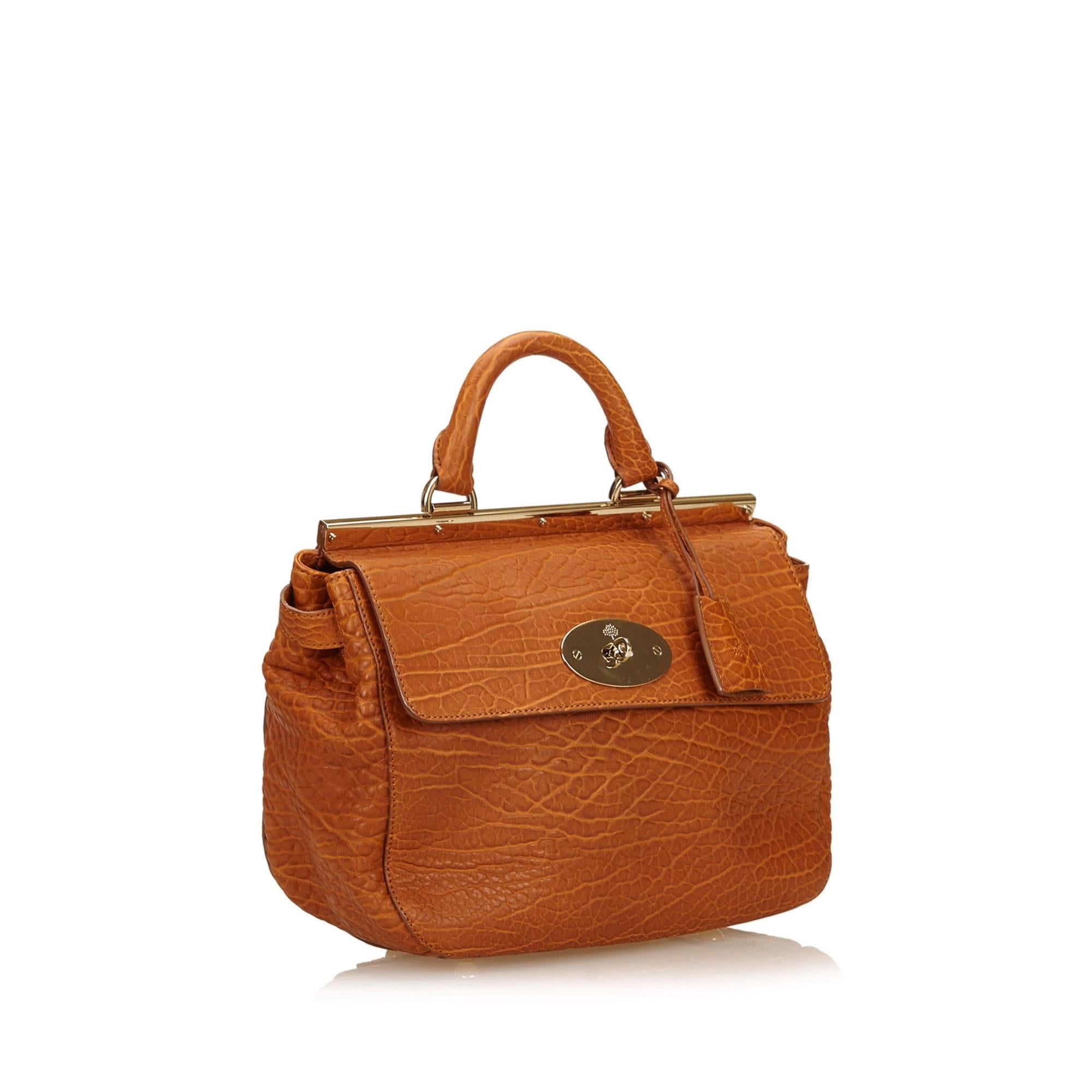 Product details:  Brown embossed leather satchel by Mulberry.  Top carry handle.  Detachable shoulder strap.  Twist-lock closure on front flap.  Lined interior with inner zip pocket.  Protective metal feet.  Goldtone hardware.  12